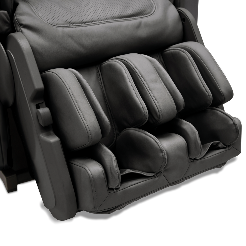 A close-up of a black massage chair, showing the headrest, backrest, and footrest. The chair is on a white background.