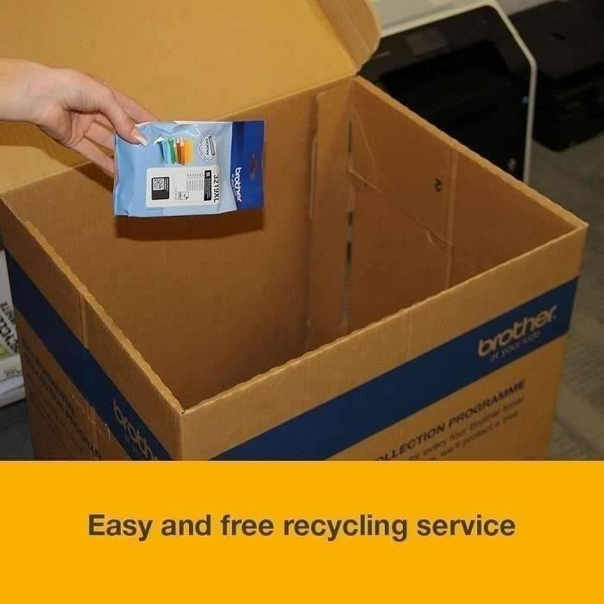 Ręka trzyma opakowanie z wkładami atramentowymi Brother nad otwartym kartonem. Pudełko ma niebieskie paski i logo Brother.