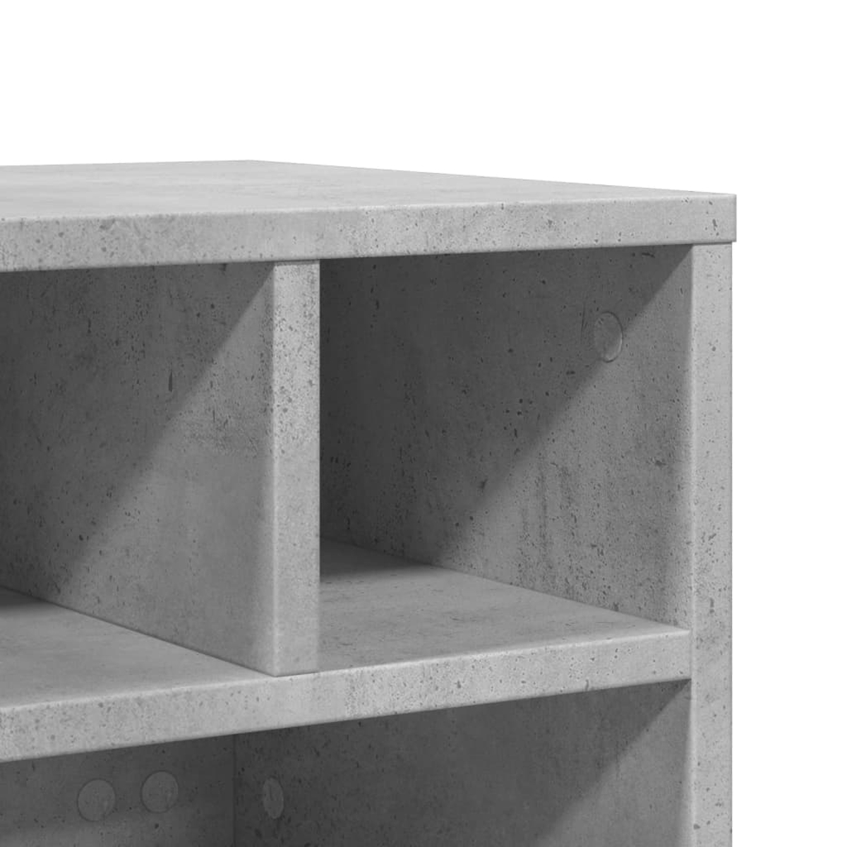 Nahaufnahme einer grauen Betonkonstruktion mit Regalen und offenen Fächern. Die Oberfläche hat ein strukturiertes, industrielles Aussehen.