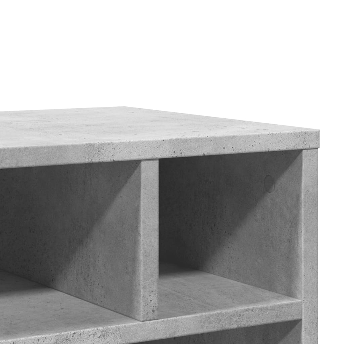 Nahaufnahme eines grauen Betonregals mit Fächern. Die Ober- und Seiten sind sichtbar, mit weißem Hintergrund. Die Textur ist rau.