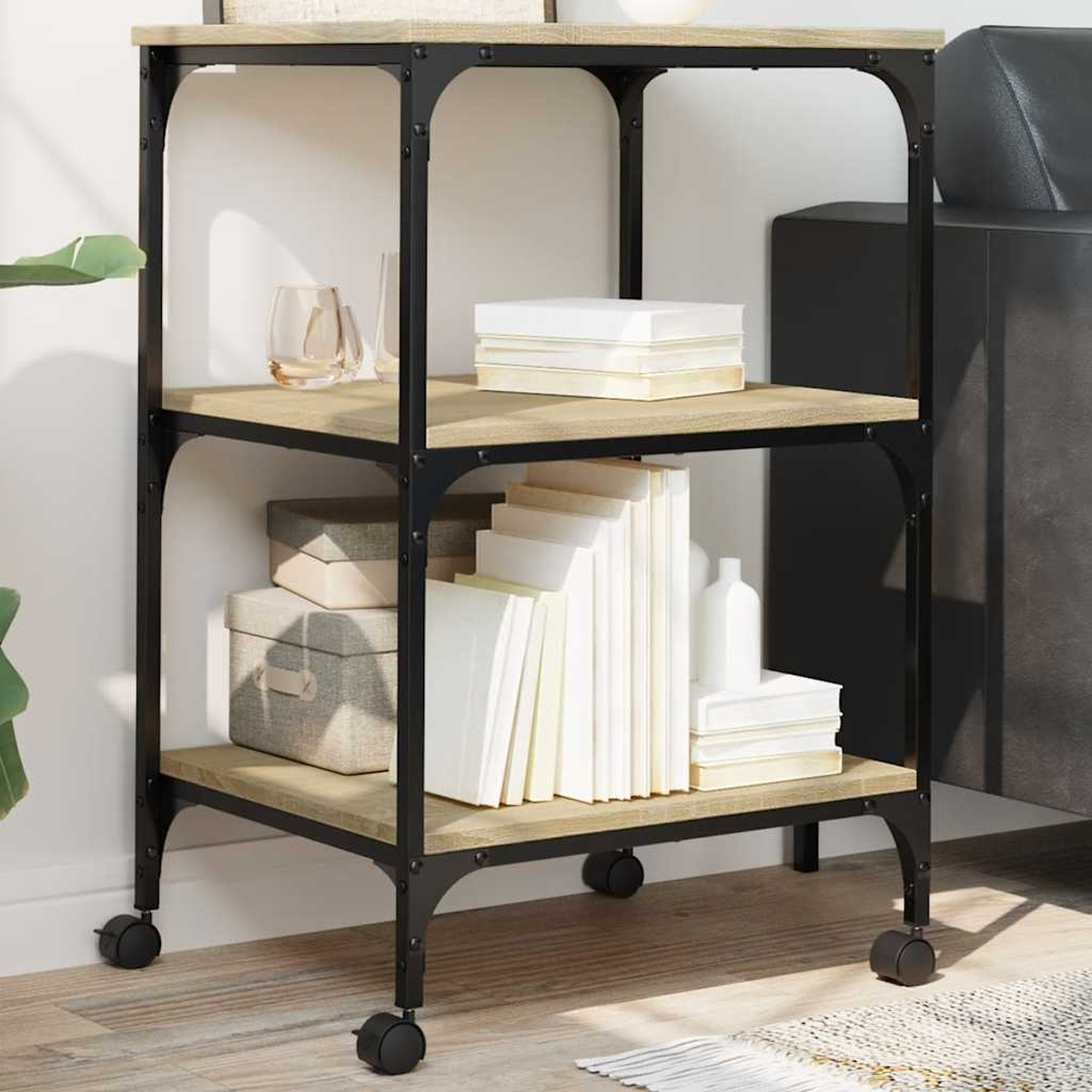 Ein dreistufiges Regal mit schwarzem Metallrahmen und Holzregalen. Bücher, Kisten und Dekorationsartikel sind auf den Regalen platziert.