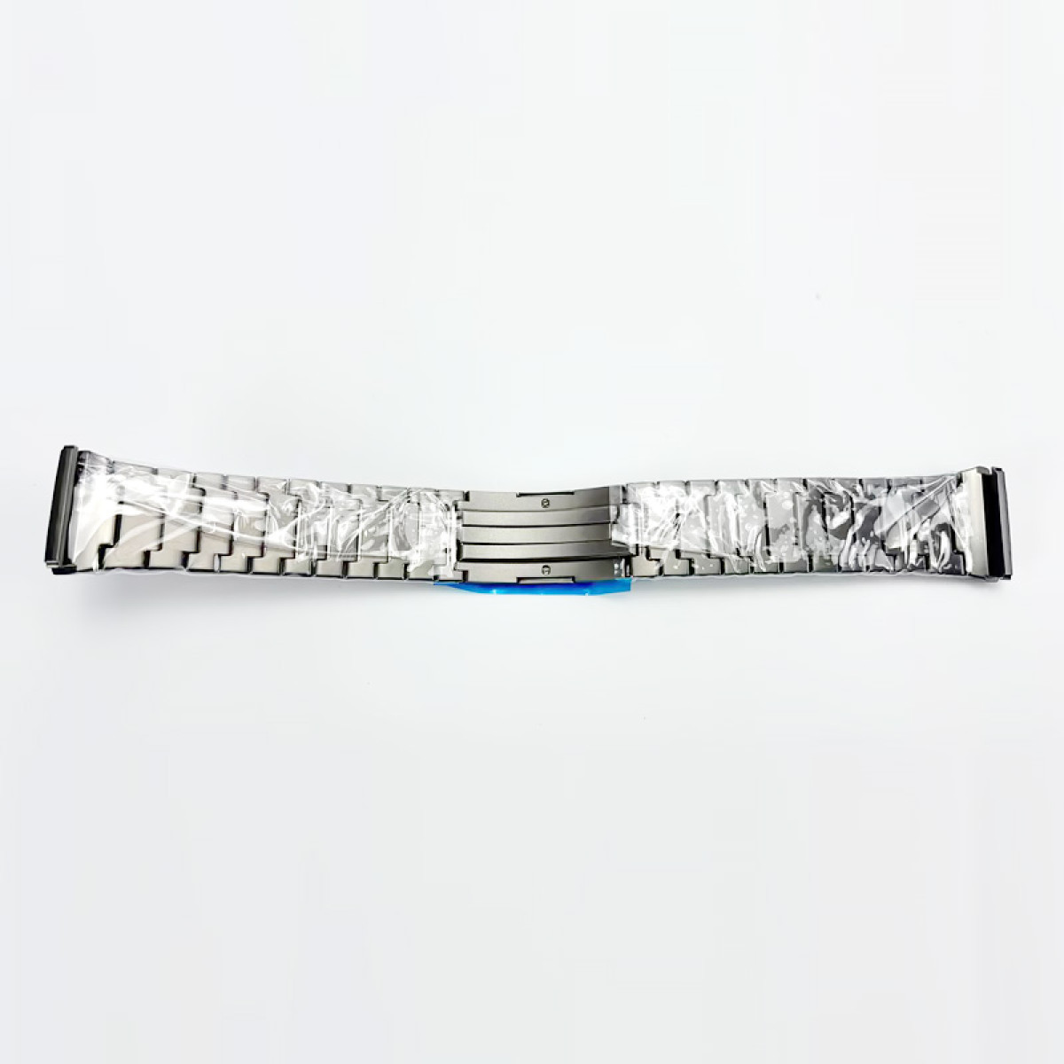 Ein neues silbernes Uhrenarmband aus Kunststoff vor weißem Hintergrund. Das Band ist zweiteilig, mit einem Verschluss in der Mitte.
