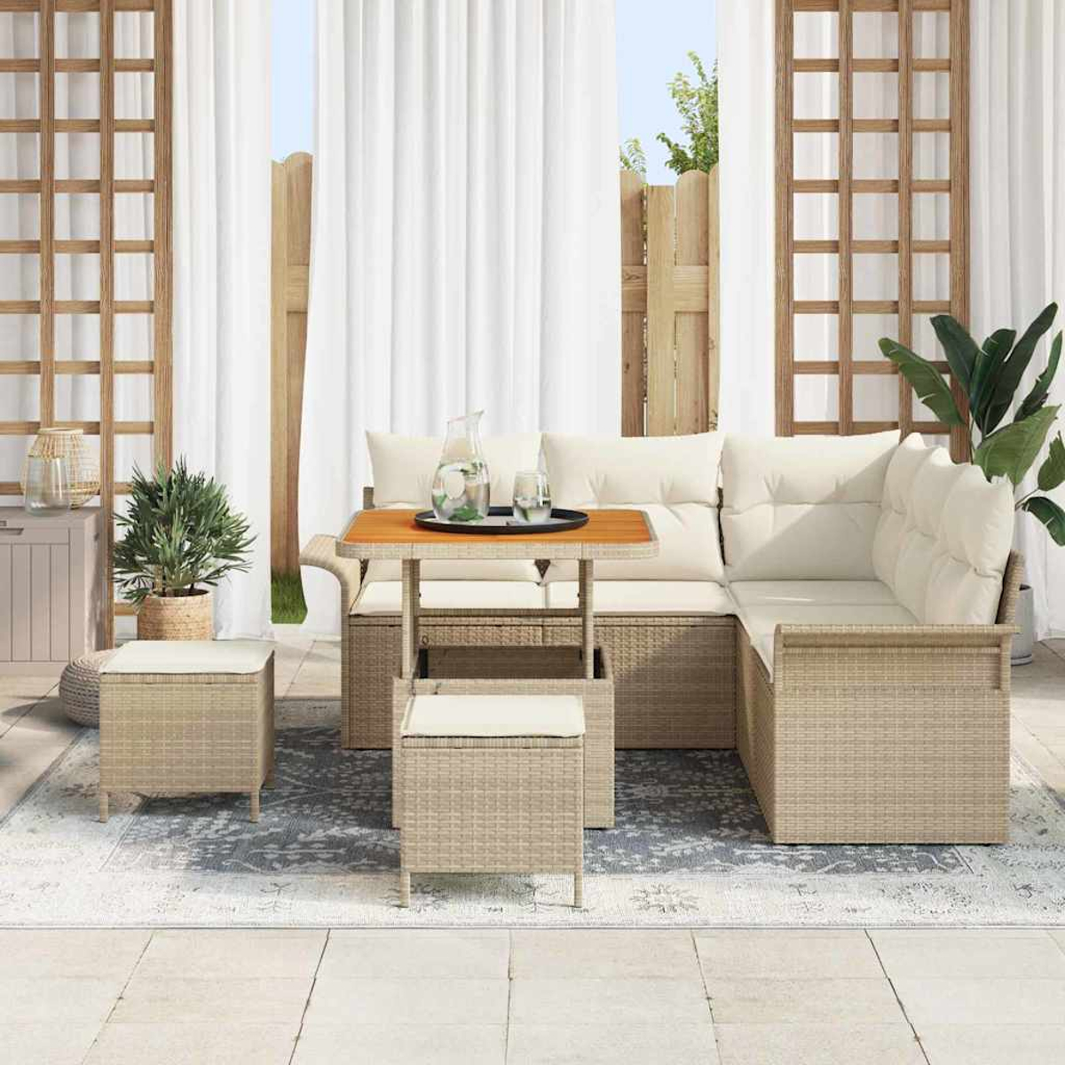 Garten-Terrassenset mit Ecksofa, kleinen Tischen und Hockern auf einem Teppich. Weiße Vorhänge und Holzgitter im Hintergrund.