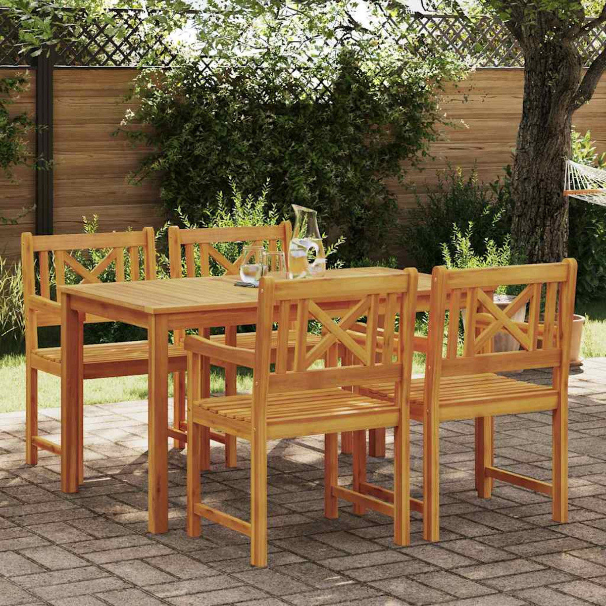 Essgruppe aus Holz im Freien, einschließlich Tisch und Stühlen, auf einer Ziegelterrasse. Grünes Laub und ein Baum sind im Hintergrund.