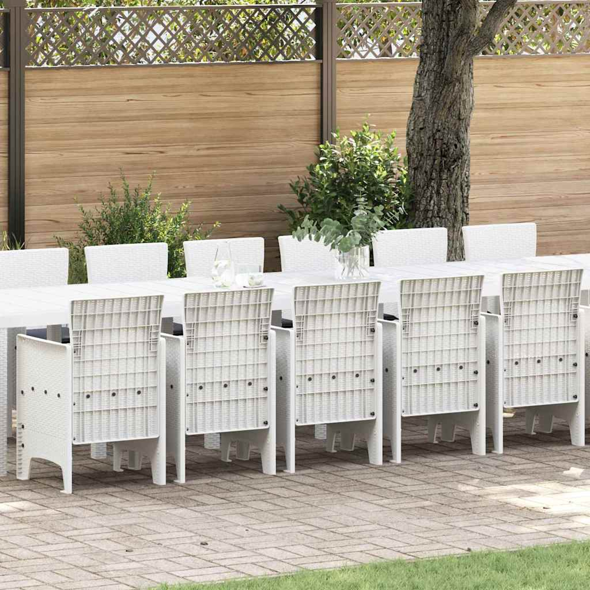 Szene im Freien. Weißer Tisch und Stühle auf der Terrasse. Hintergrund: Holzzaun, Baum und Grün.