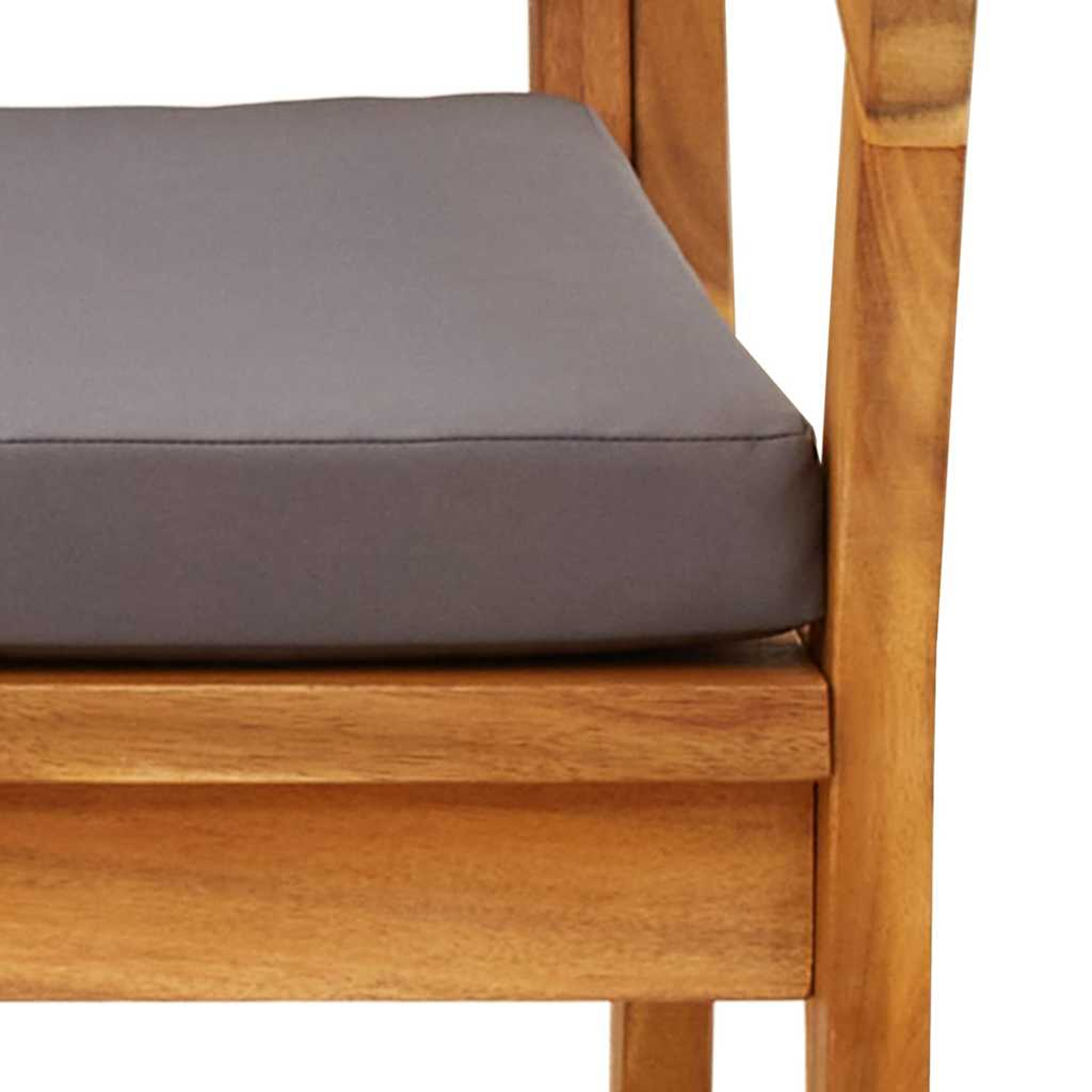 Primer plano de una silla de madera con un cojín gris. La silla tiene un acabado de madera natural.