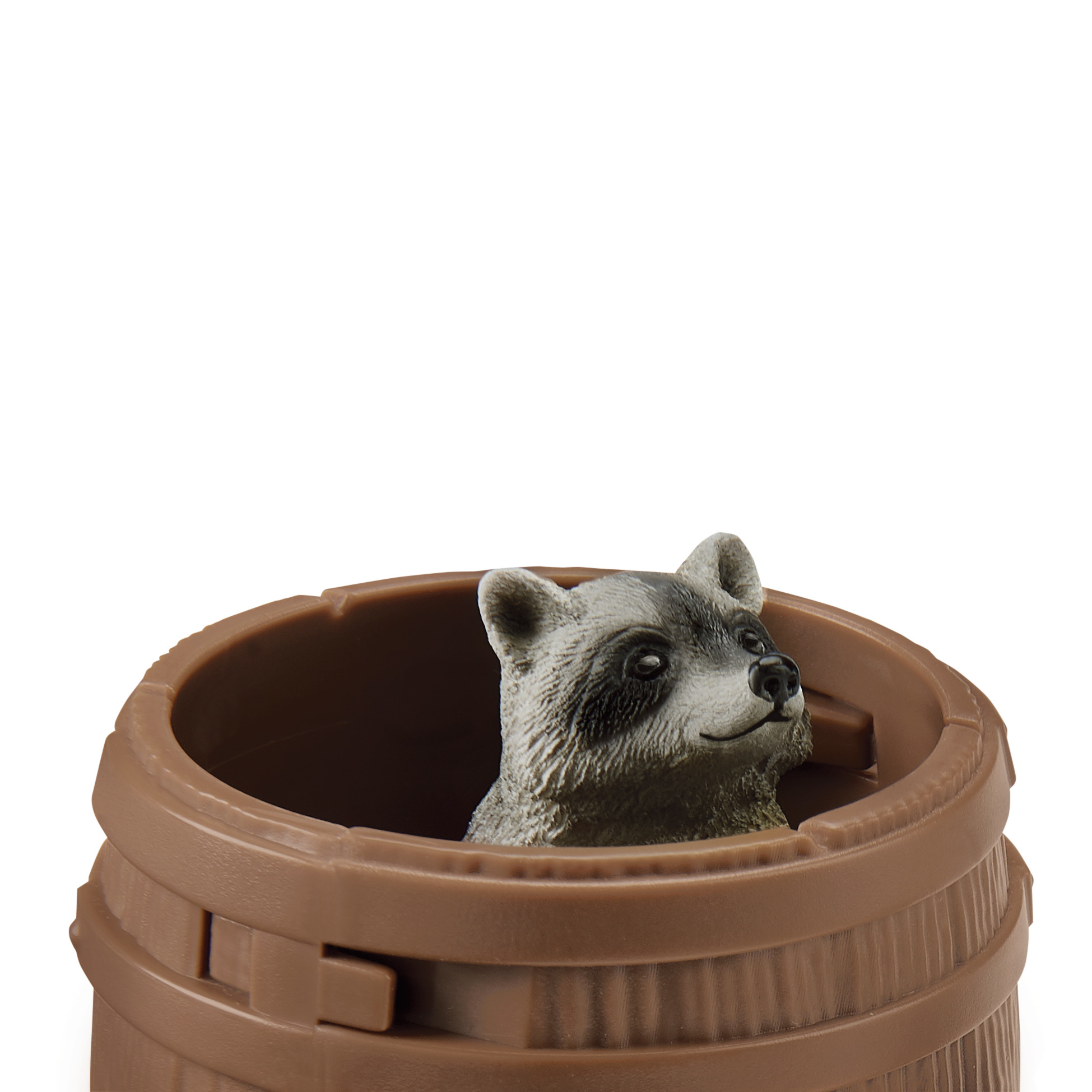 Ein Spielzeug-Waschbär blickt aus einem braunen Fass. Der Hintergrund ist weiß.