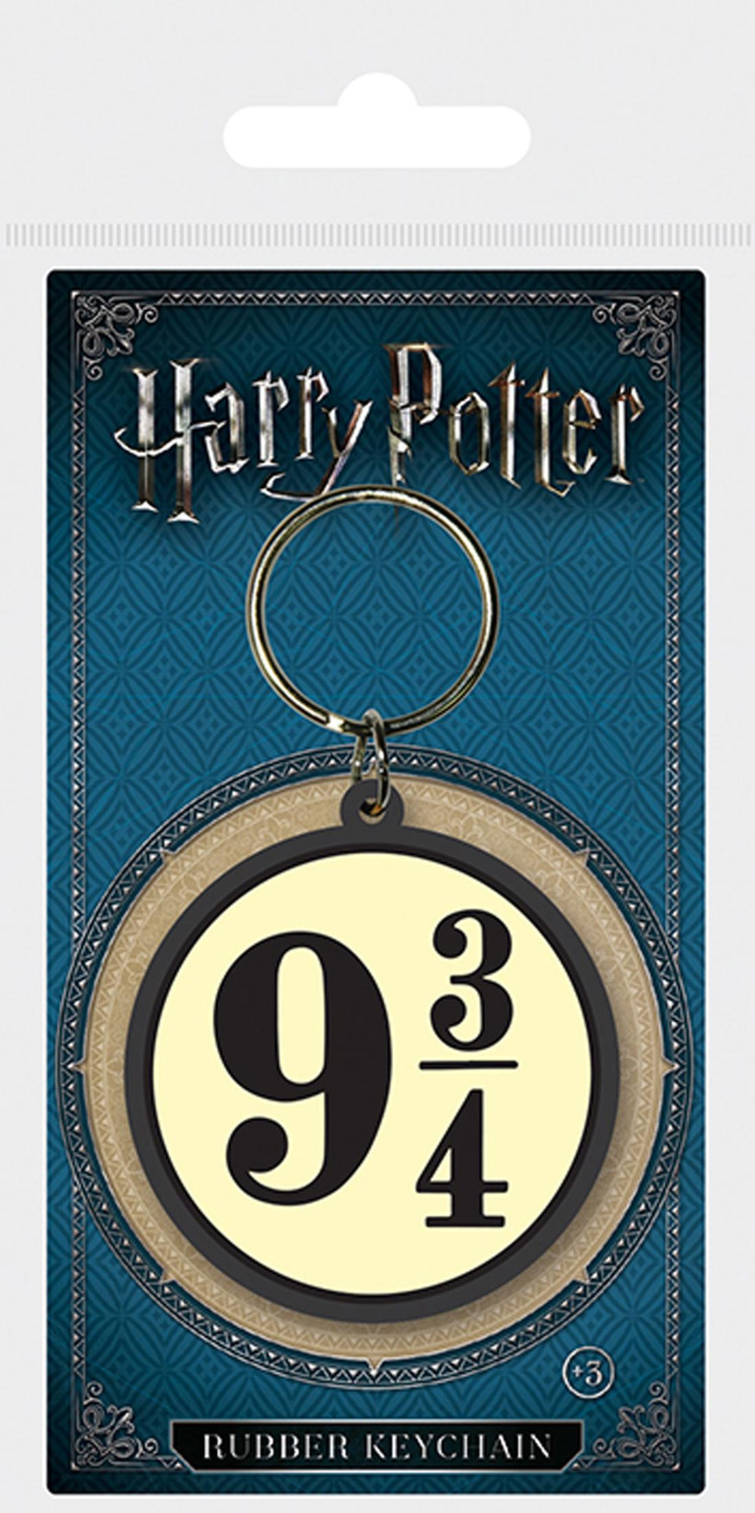 Harry-Potter-Schlüsselanhänger mit dem Logo 9 3/4. Der Hintergrund ist blau mit Muster. Der Anhänger ist golden und hat die Aufschrift "Rubber Keychain".