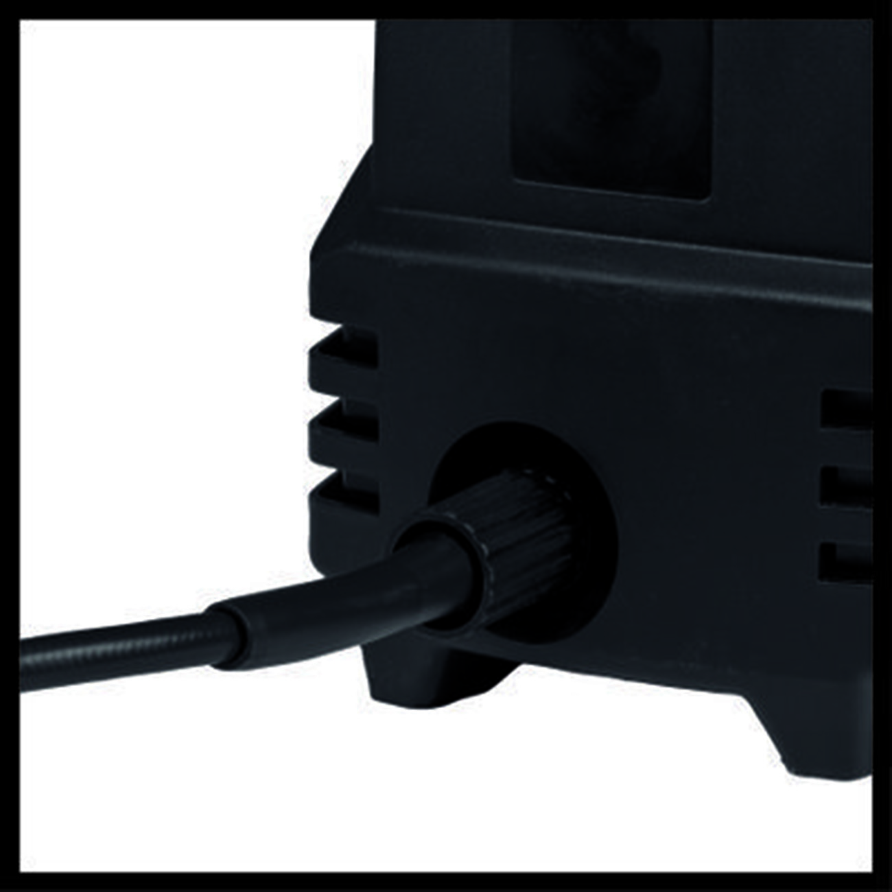 Ein schwarzes Gerät mit einem eingesteckten schwarzen Kabel. Das Kabel tritt durch eine kreisförmige Öffnung in das Gerät ein. Weißer Hintergrund.