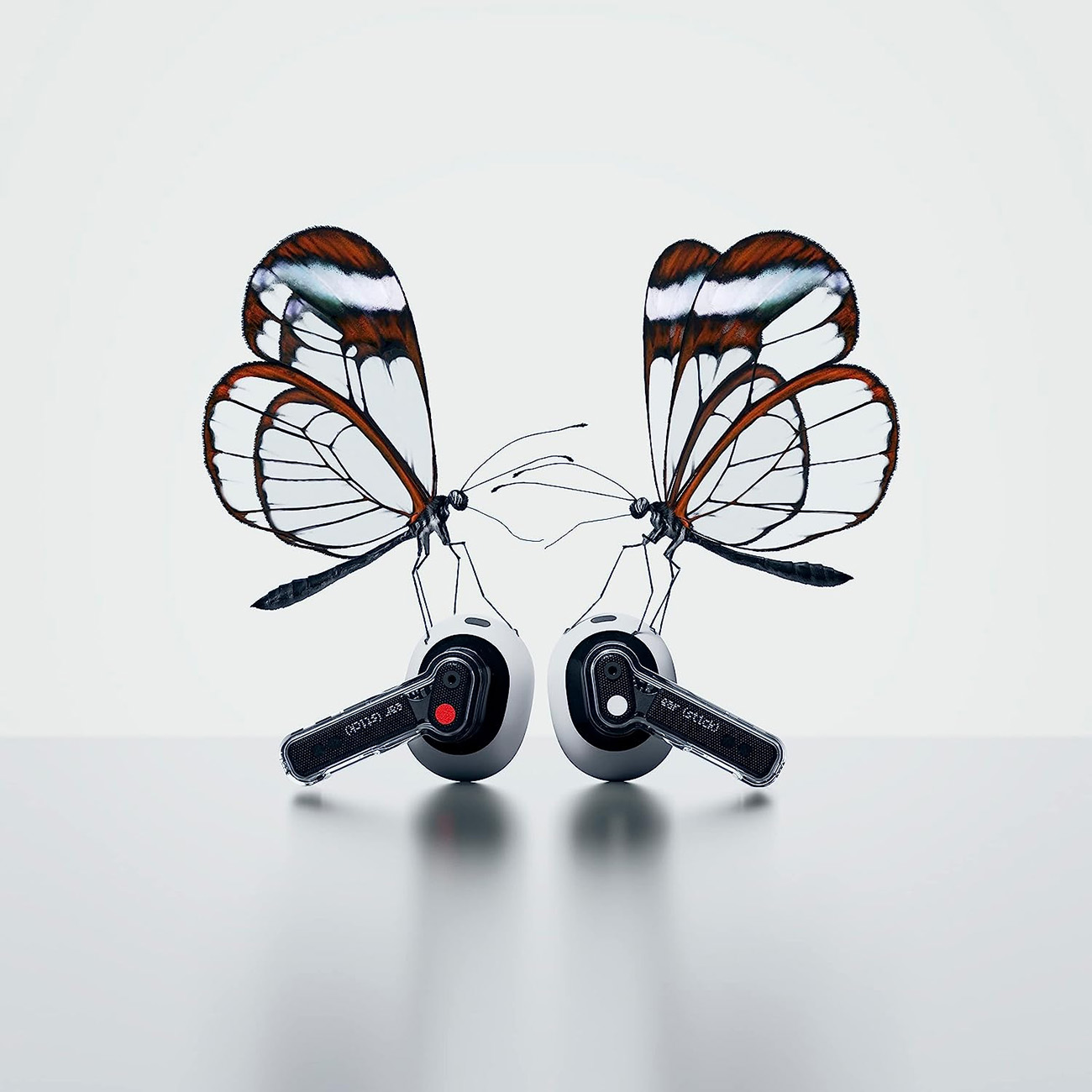 Dos mariposas con alas transparentes y bordes marrones están conectadas a dos auriculares.