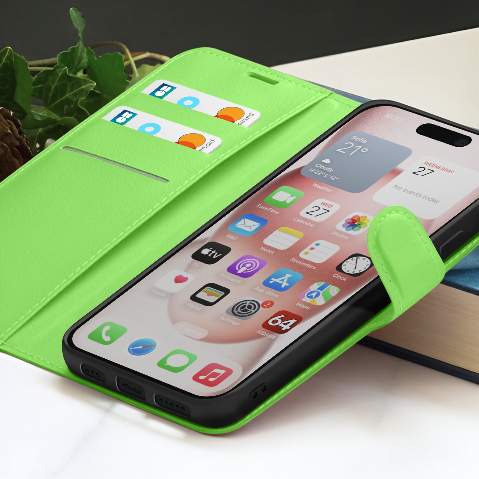 Un étui de téléphone vert citron avec un smartphone affichant des icônes d'applications. Des cartes de crédit sont dans l'étui. Un livre en arrière-plan.