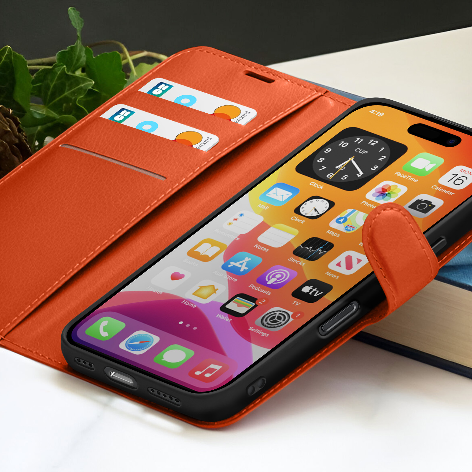 Un étui de téléphone orange avec un téléphone affichant des icônes d'application. Deux cartes de crédit sont visibles dans la fente de l'étui. Une application d'horloge est ouverte.