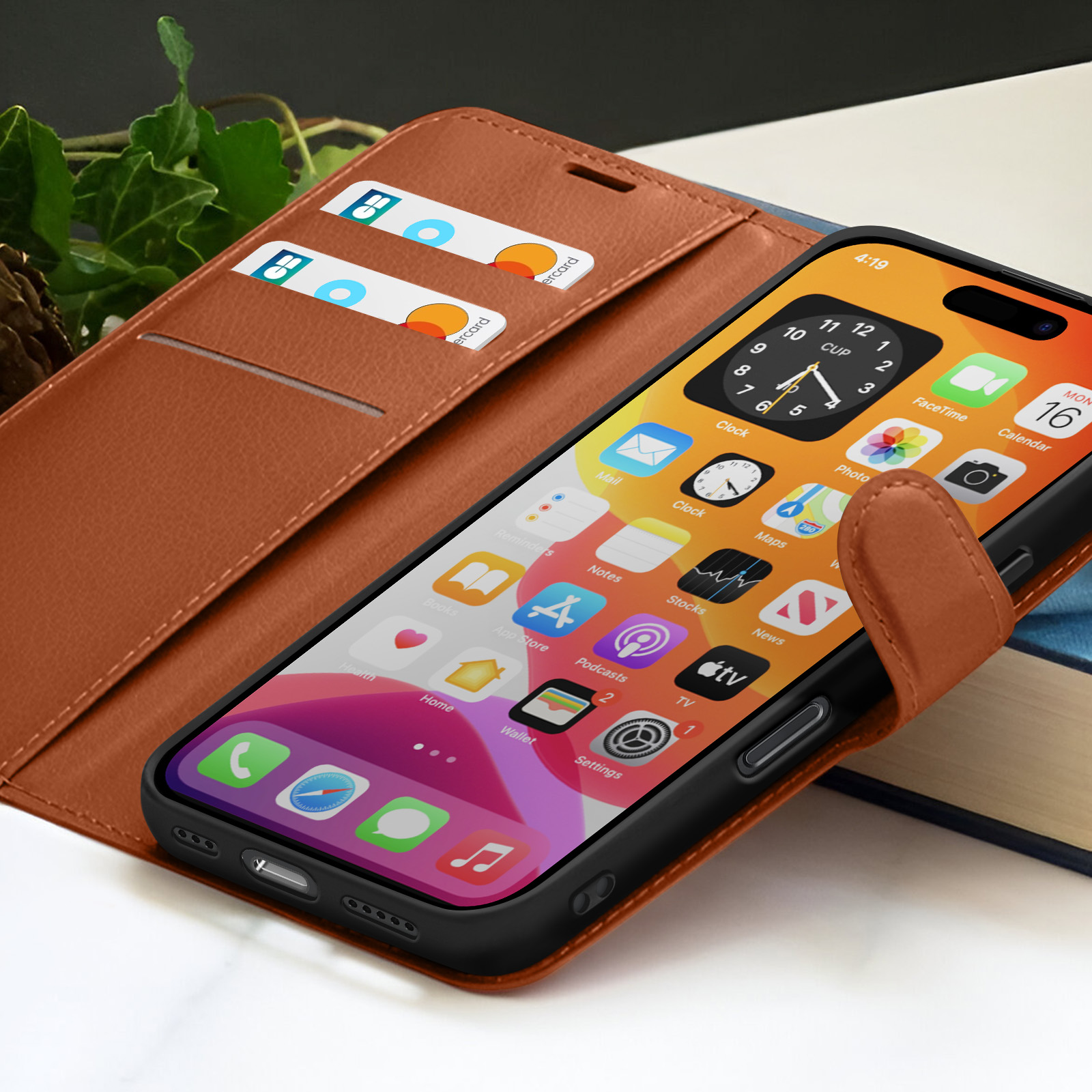 Een telefoon in een bruine leren hoes met apps. Twee creditcards zitten in de hoes. De tijd is 4:19 op het scherm.