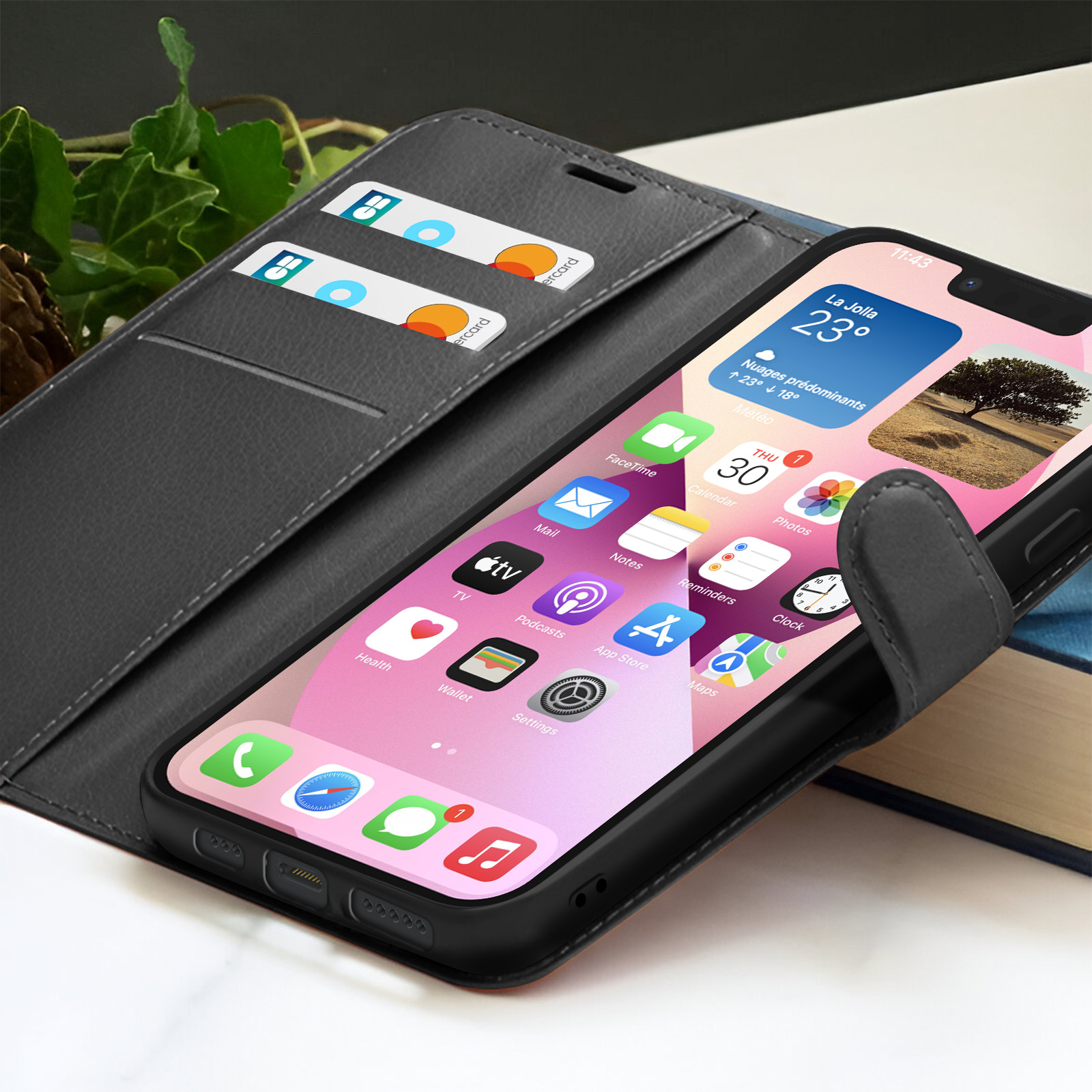 iPhone in een portemonneehoes, met het scherm met weerinfo, kaarten in de hoes en een boek op de achtergrond.