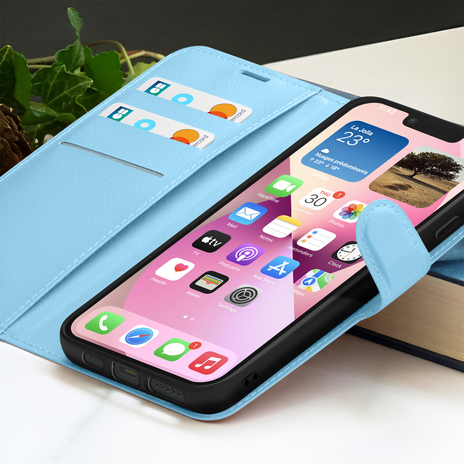 Een iPhone in een lichtblauwe hoes. Het scherm toont apps en een weerwidget. Creditcards zitten in een sleuf.