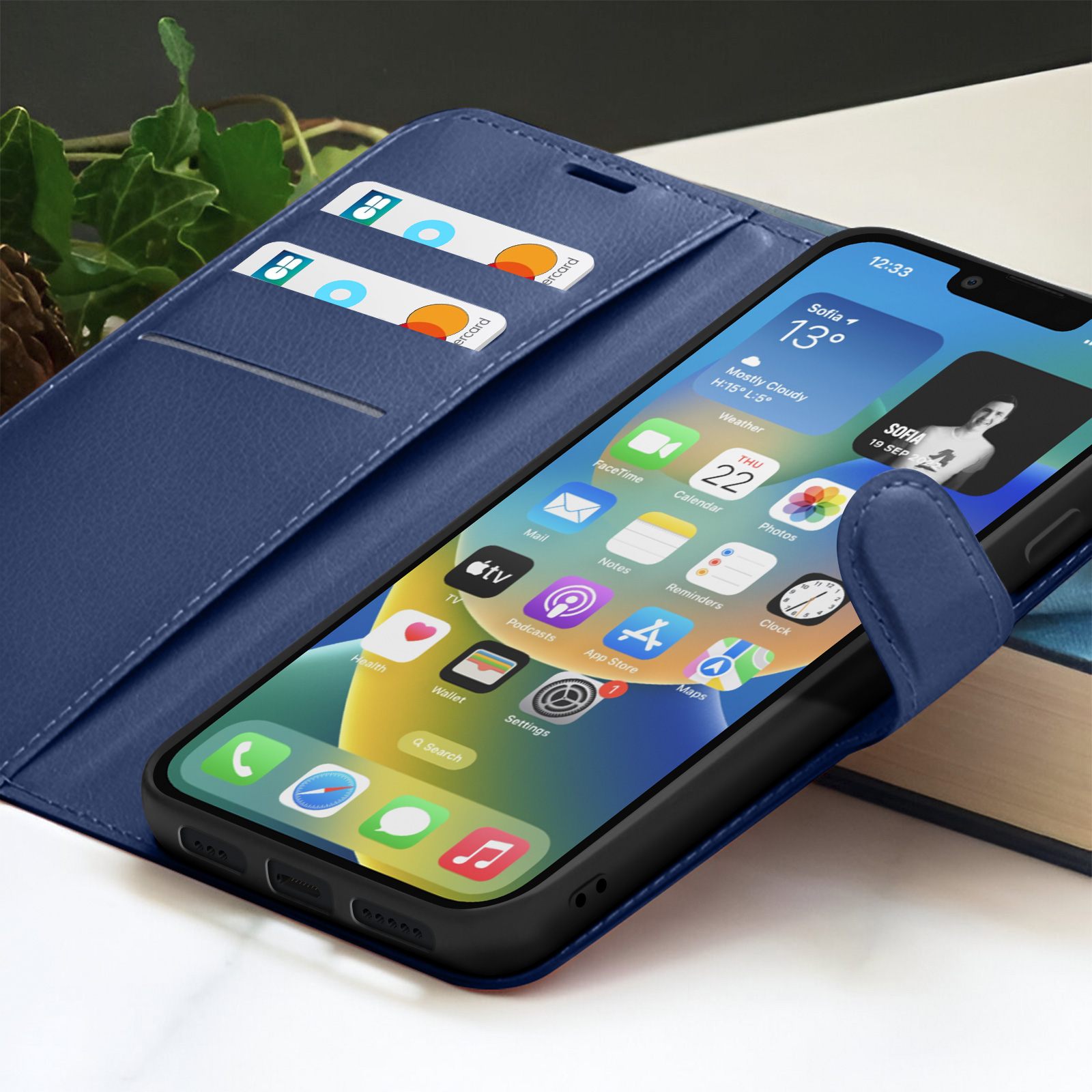 Een smartphone in een blauwe leren hoes is open, met app-iconen. Twee kaarten zitten in de kaartsleuven. De achtergrond is wazig.