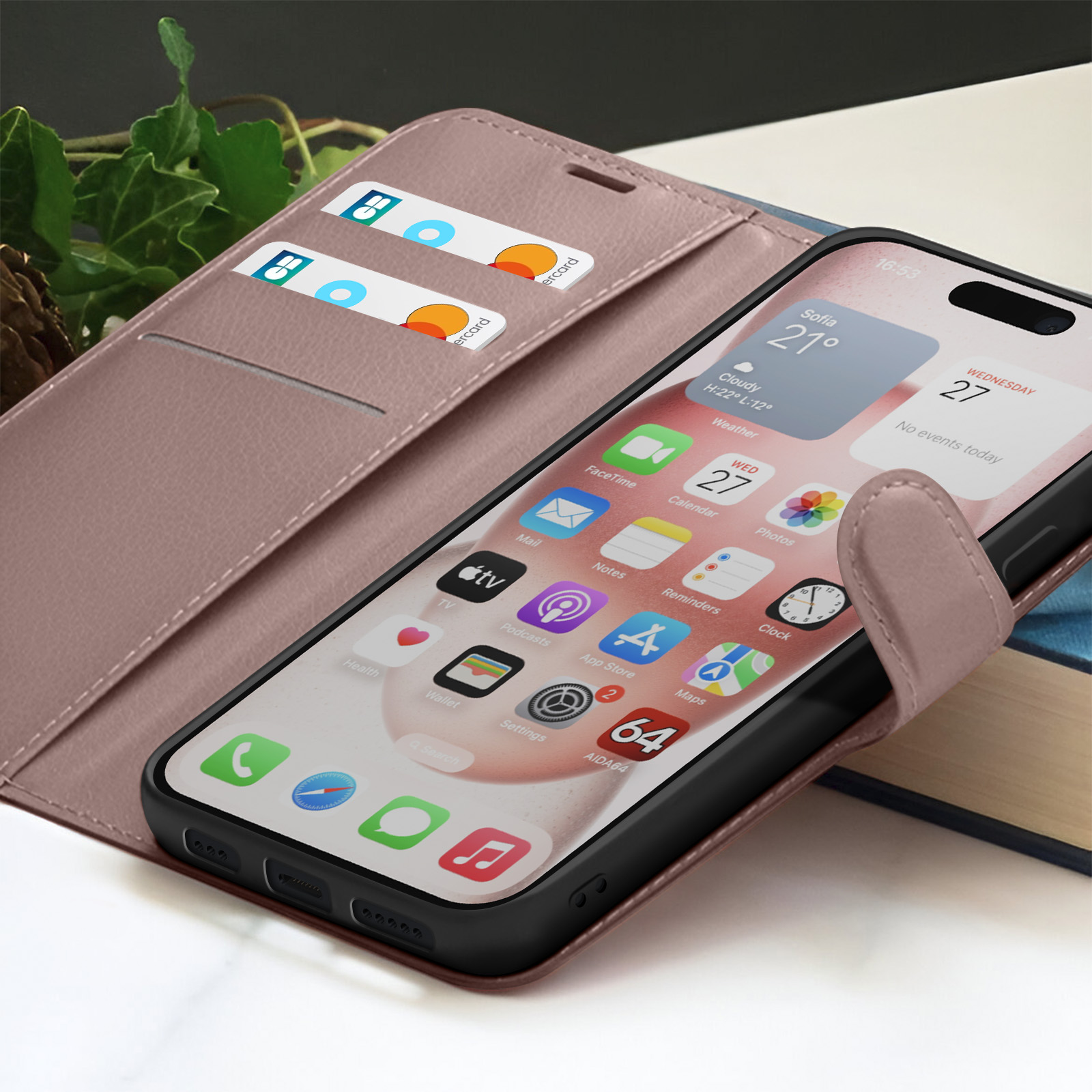 Un smartphone affiche des applications et des informations météo. Il est dans un étui avec des fentes pour cartes. Des cartes et un livre sont visibles en arrière-plan.