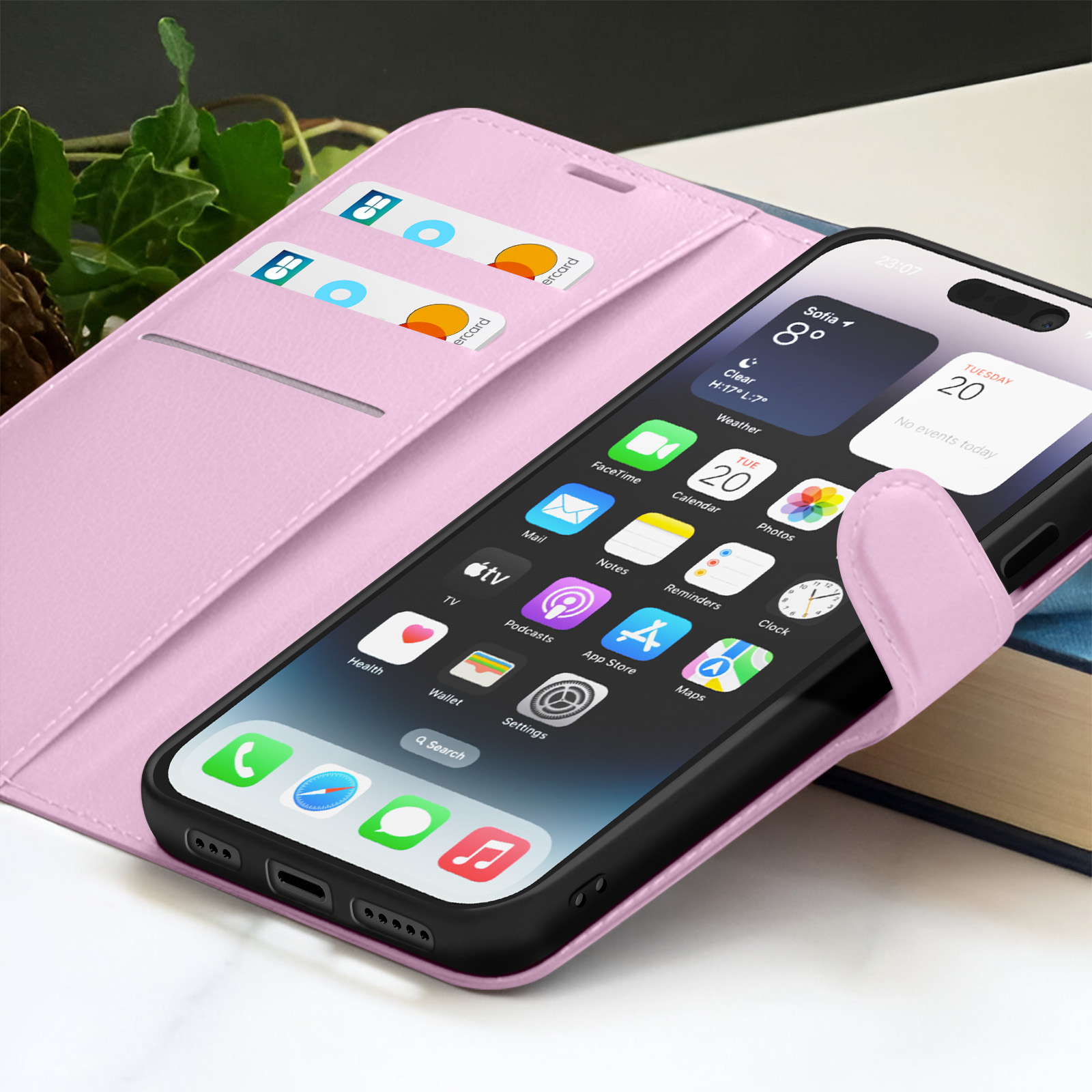 Una funda rosa para teléfono con un teléfono negro dentro. El teléfono muestra el clima y los iconos de las aplicaciones. Tarjetas de crédito en ranura.