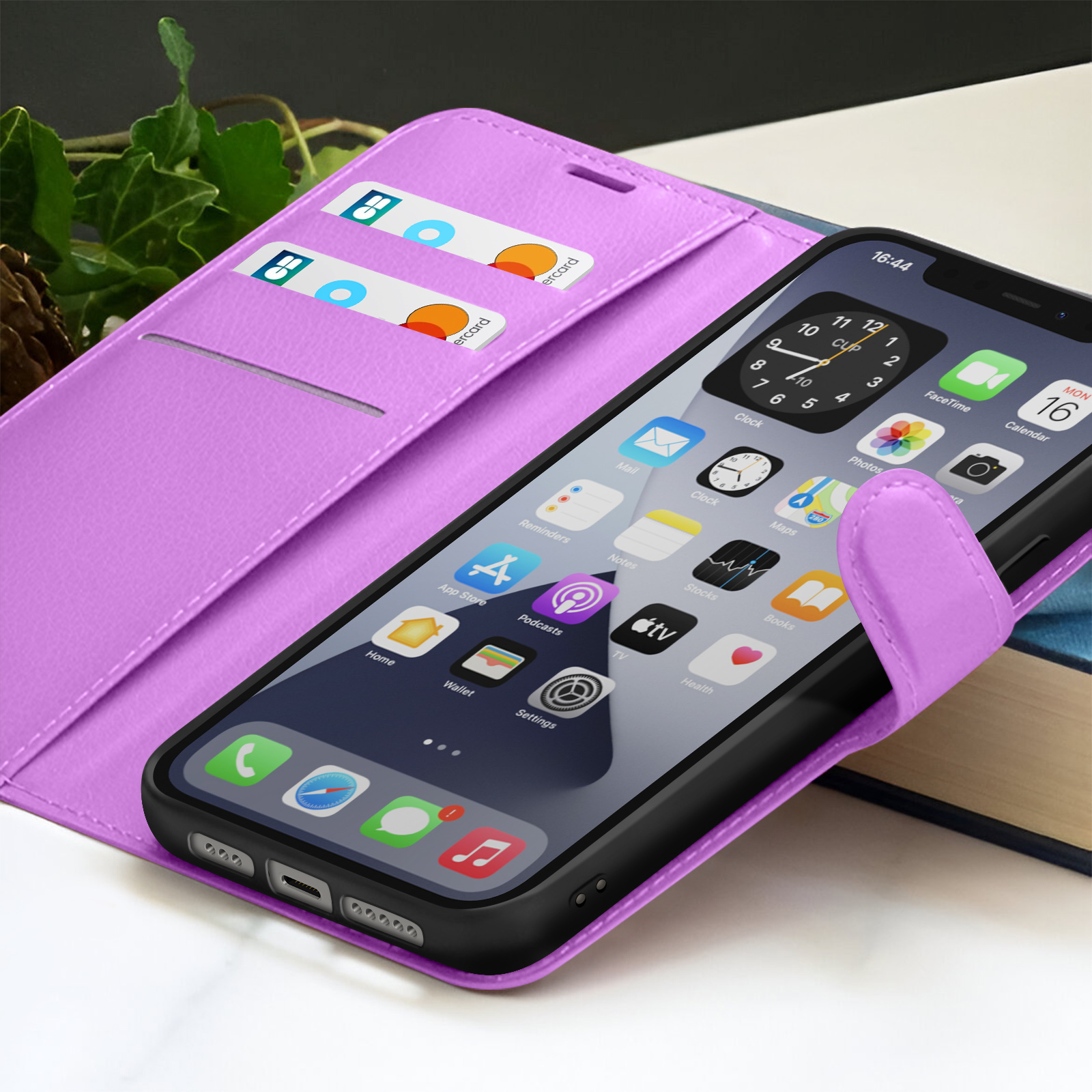 Een iPhone in een paarse hoes met zichtbare creditcards. De telefoon toont apps op het scherm. Een boek op de achtergrond.