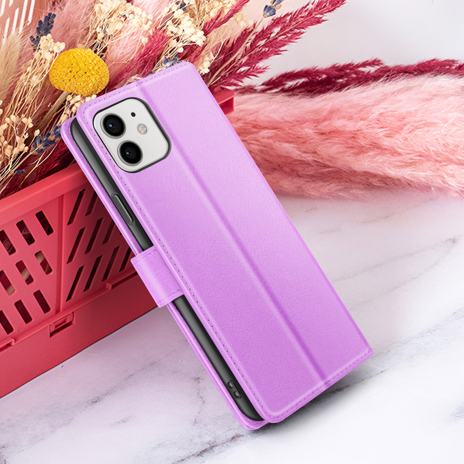 Een paarse telefoonhoes wordt getoond. Er zit een telefoon in. De achtergrond heeft roze en rode decoratieve elementen. Marmeren oppervlak.
