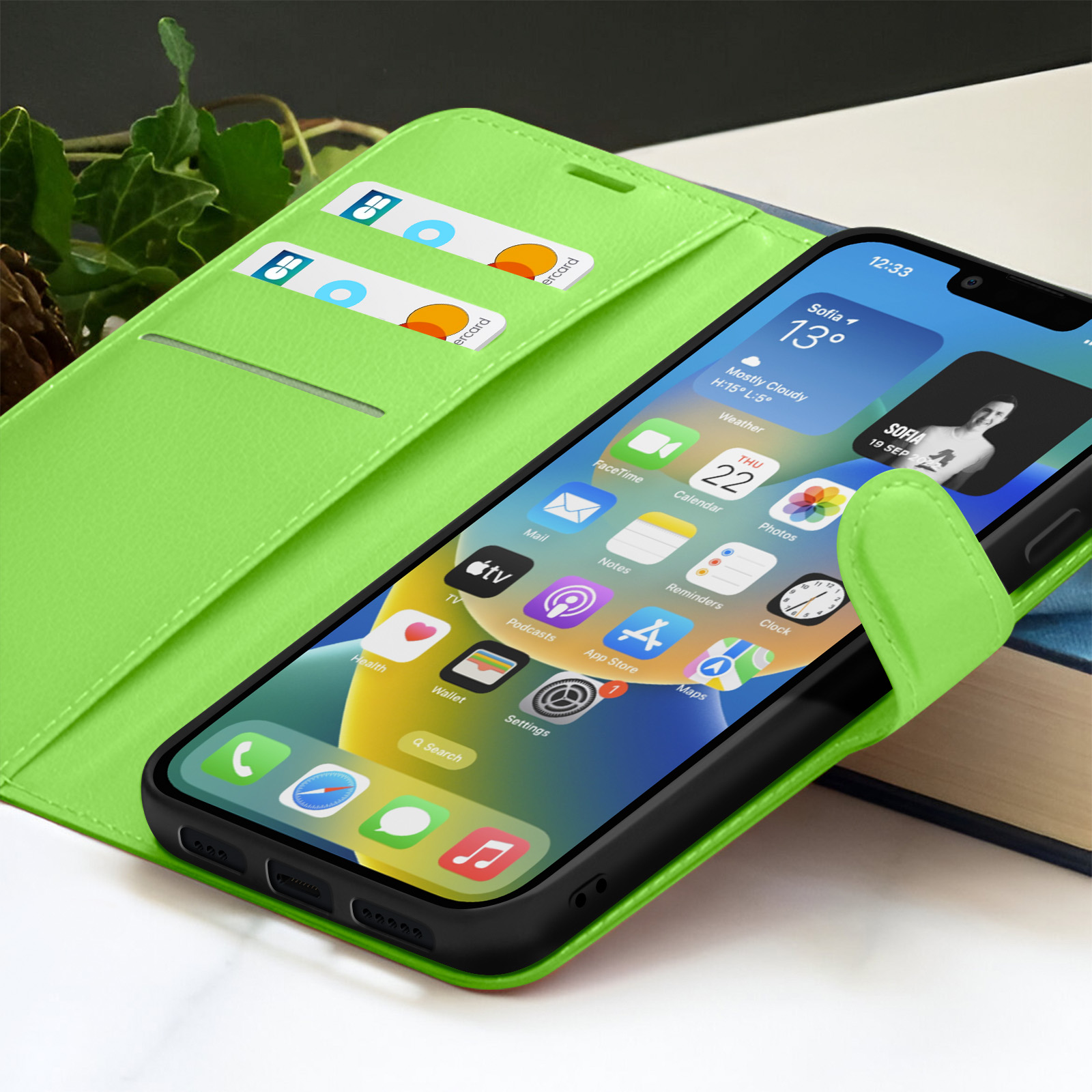 Groene telefoonhoes met een smartphone met app-pictogrammen. Creditcards zichtbaar. Achtergrond is wazig.