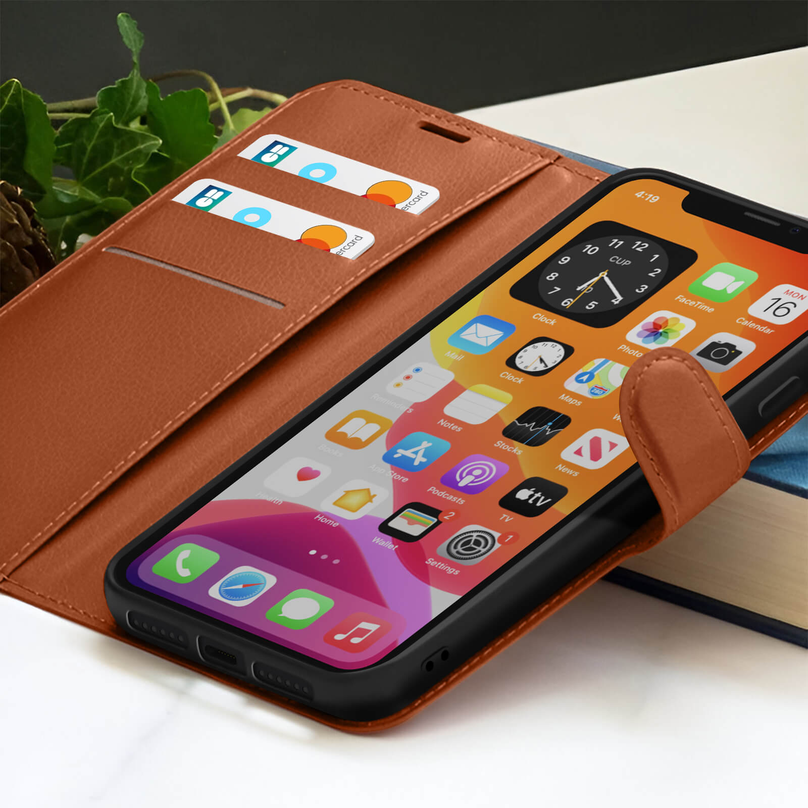 Een iPhone in een bruine lederen hoes, met het beginscherm. Er zitten twee kaarten in een kaartsleuf.