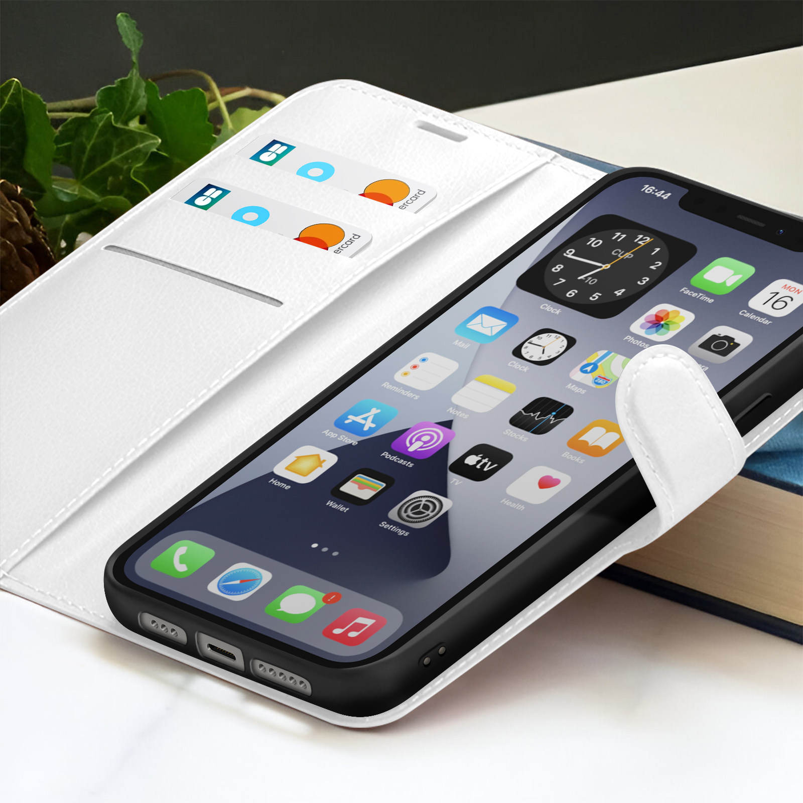 Een iPhone in een witte hoes is open en toont apps. Creditcards in de hoes. De tijd is 16:44.