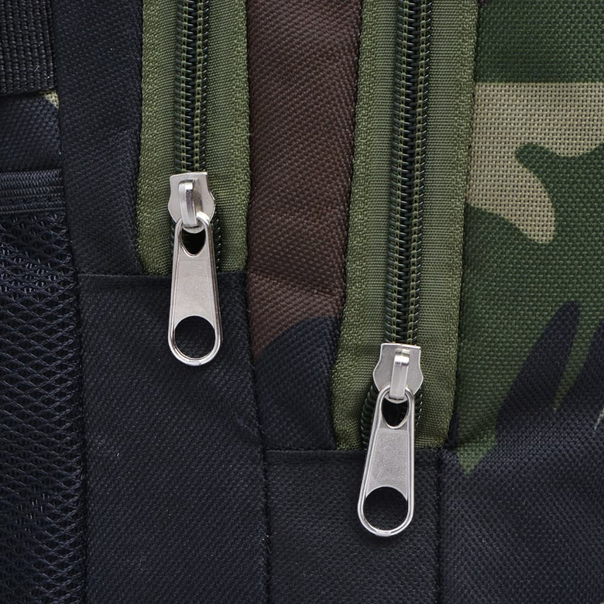 Nahaufnahme eines Rucksacks mit zwei silbernen Reißverschlüssen. Die Tasche hat ein Tarnmuster mit grünen, braunen und schwarzen Farben.
