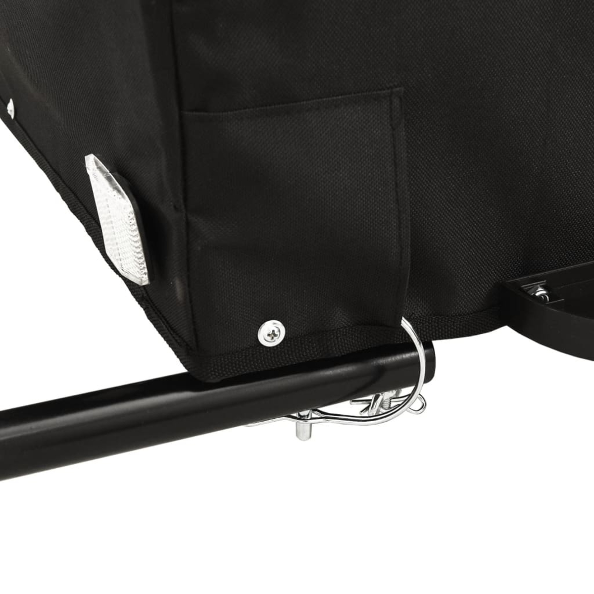 Nahaufnahme eines schwarzen Stoffs mit reflektierender Oberfläche, Metallstange und silbernem Verschluss. Der Stoff hat eine kleine Tasche.