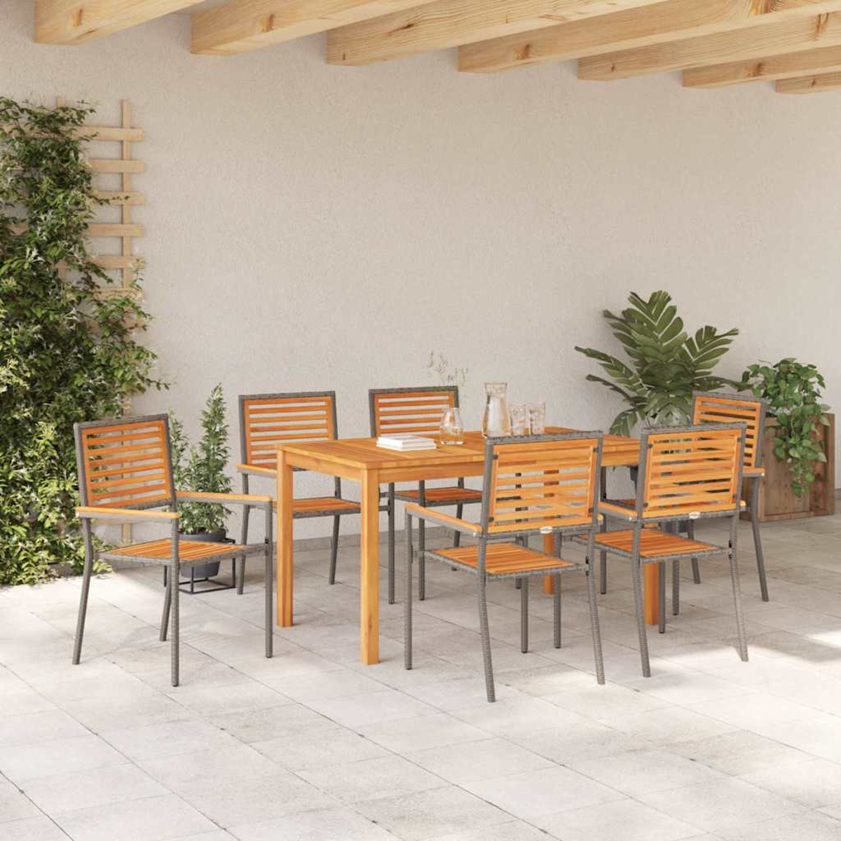 Juego de comedor al aire libre con mesa y sillas de madera. Plantas y vigas en el fondo. Suelo de baldosas.