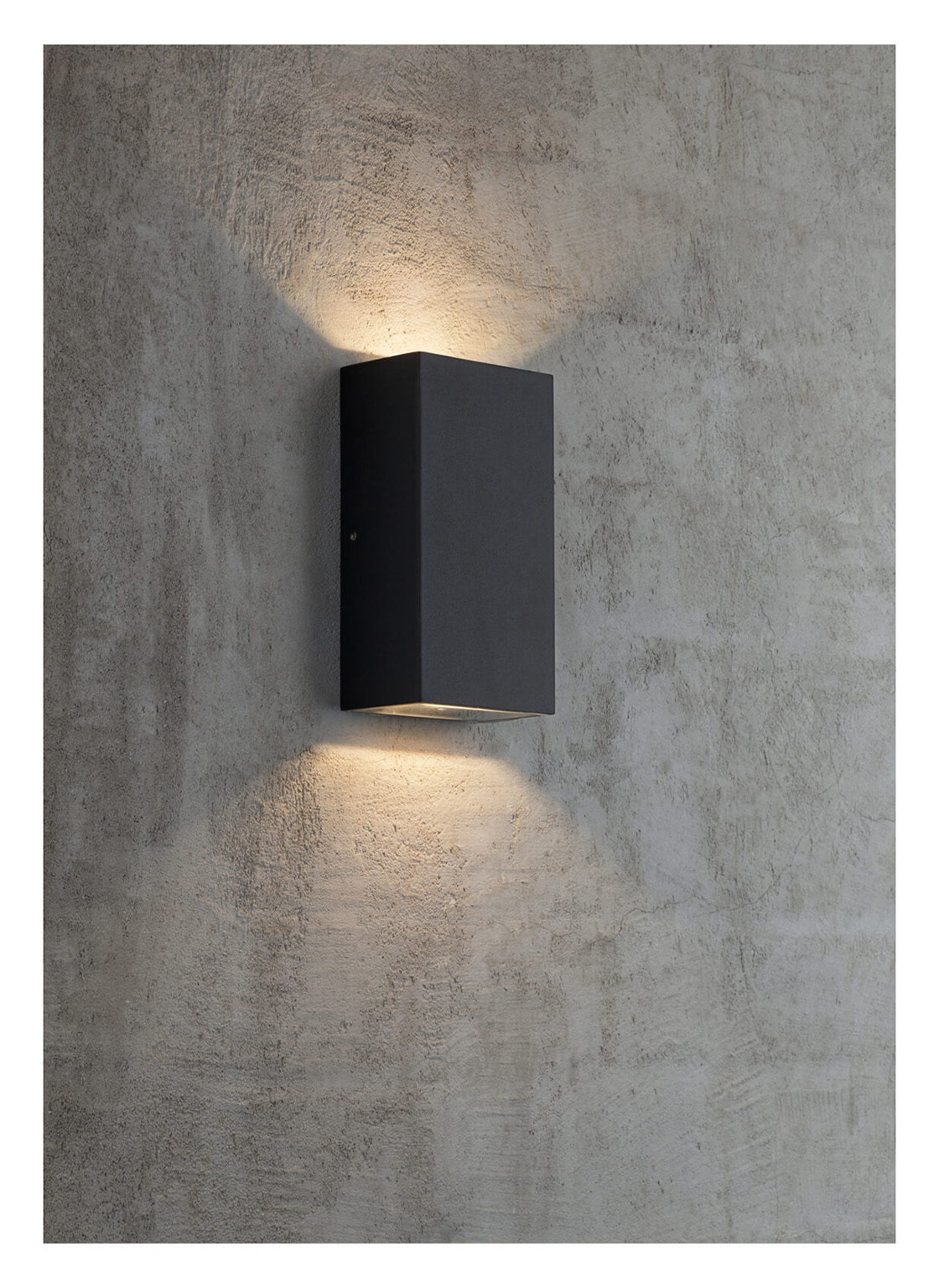 Eine schwarze, rechteckige Wandleuchte ist an einer strukturierten grauen Wand befestigt. Licht geht von oben und unten aus.