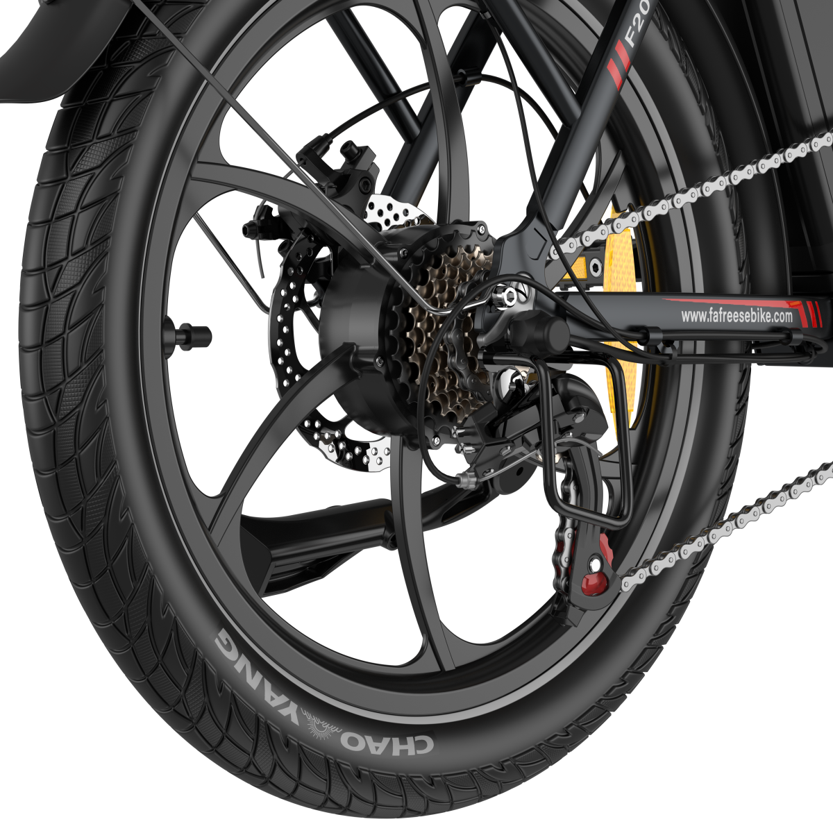 Zbliżenie na koło roweru. Czarna opona z napisem 'CHAO YANG'. Widoczne biegi, łańcuch i hamulce tarczowe.