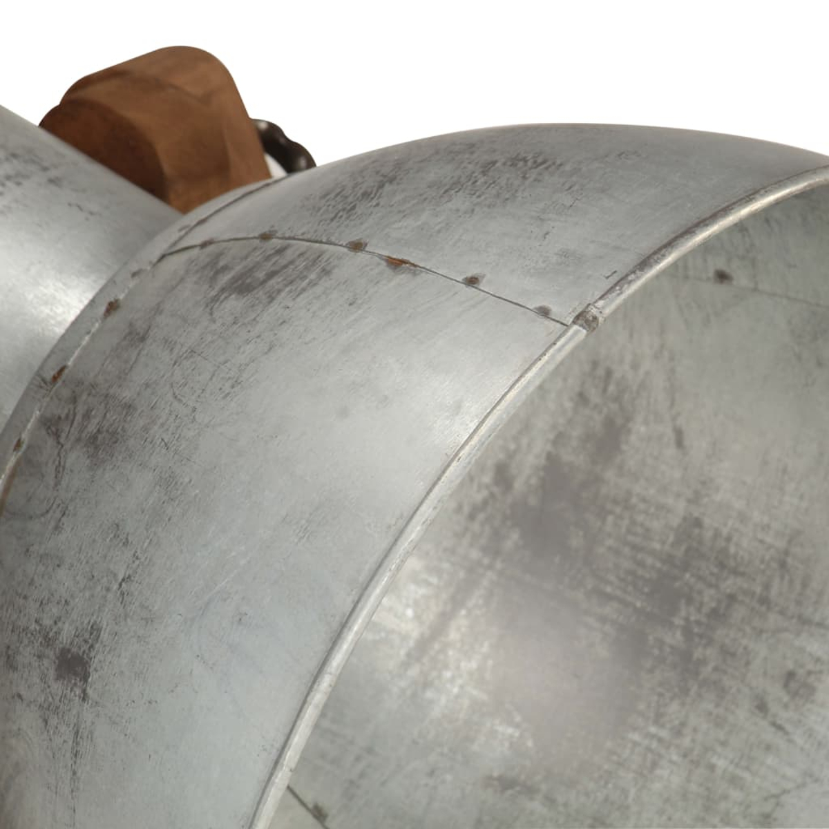 Nahaufnahme eines Metallobjekts. Das Objekt scheint ein metallischer Zylinder zu sein, mit sichtbaren Nieten und Kratzern auf der Oberfläche.
