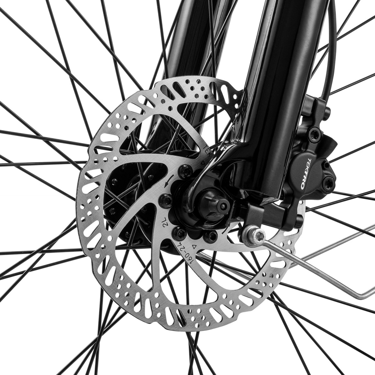 Zbliżenie koła roweru z hamulcem tarczowym. Srebrny wirnik jest perforowany, a czarny zacisk ma markę Tektro.