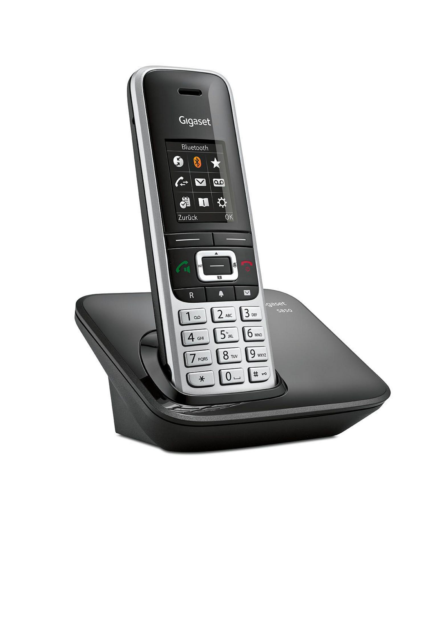 Un téléphone sans fil Gigaset sur sa base de chargement. Le téléphone est noir et argenté, avec un écran et des boutons numériques.