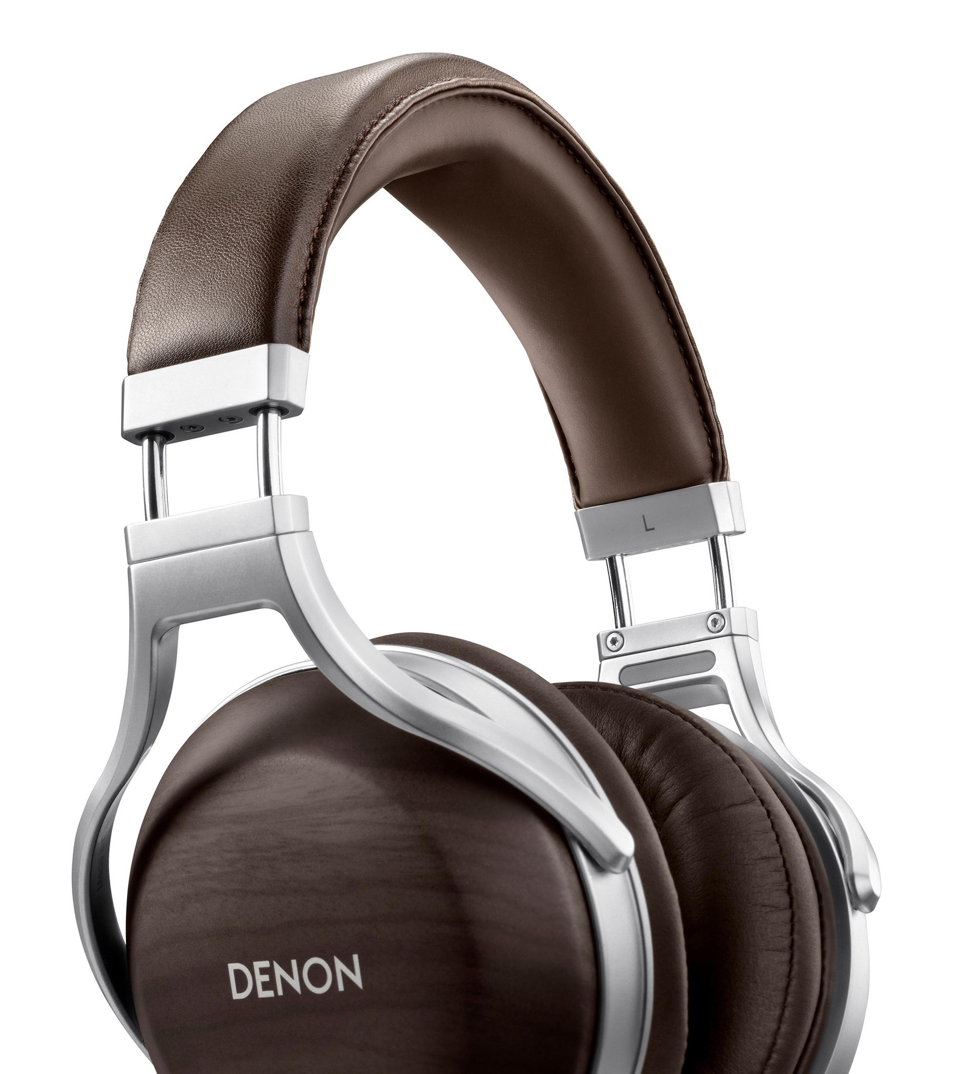 Primo piano delle cuffie Denon. Padiglioni e fascia in pelle marrone con montatura in metallo argentato. Sfondo bianco.