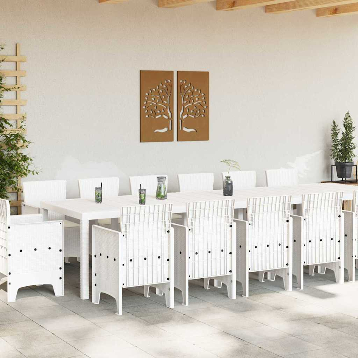 Essgruppe im Freien mit weißem Tisch und Stühlen. Dekorative Baumtafeln an der Wand. Getränke auf dem Tisch. Pflanzen an der Seite.