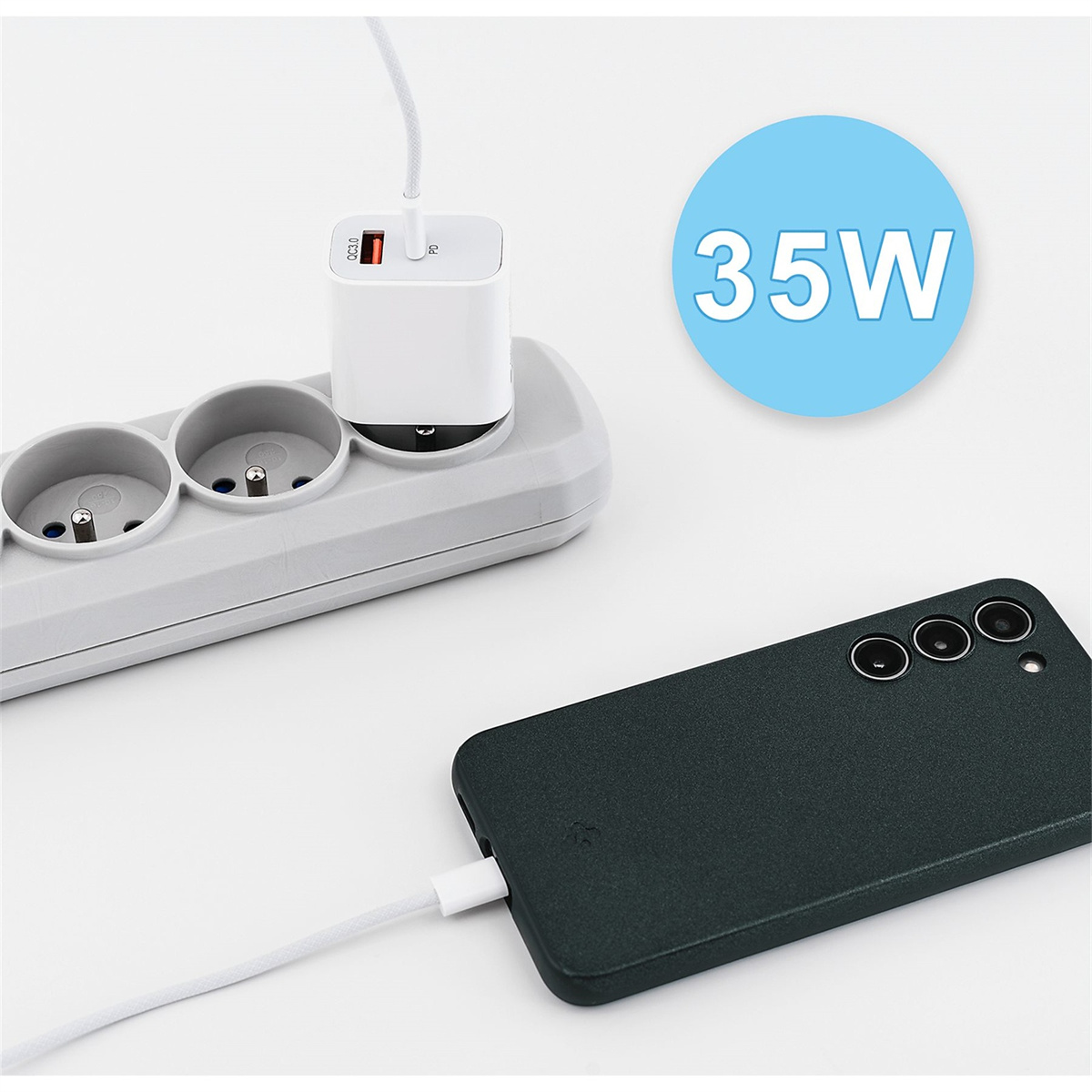 Ein Telefon wird mit einem weißen Kabel aufgeladen. Ein weißes Ladegerät ist an eine Steckdosenleiste angeschlossen. Ein blauer Kreis hat den Text 35W.