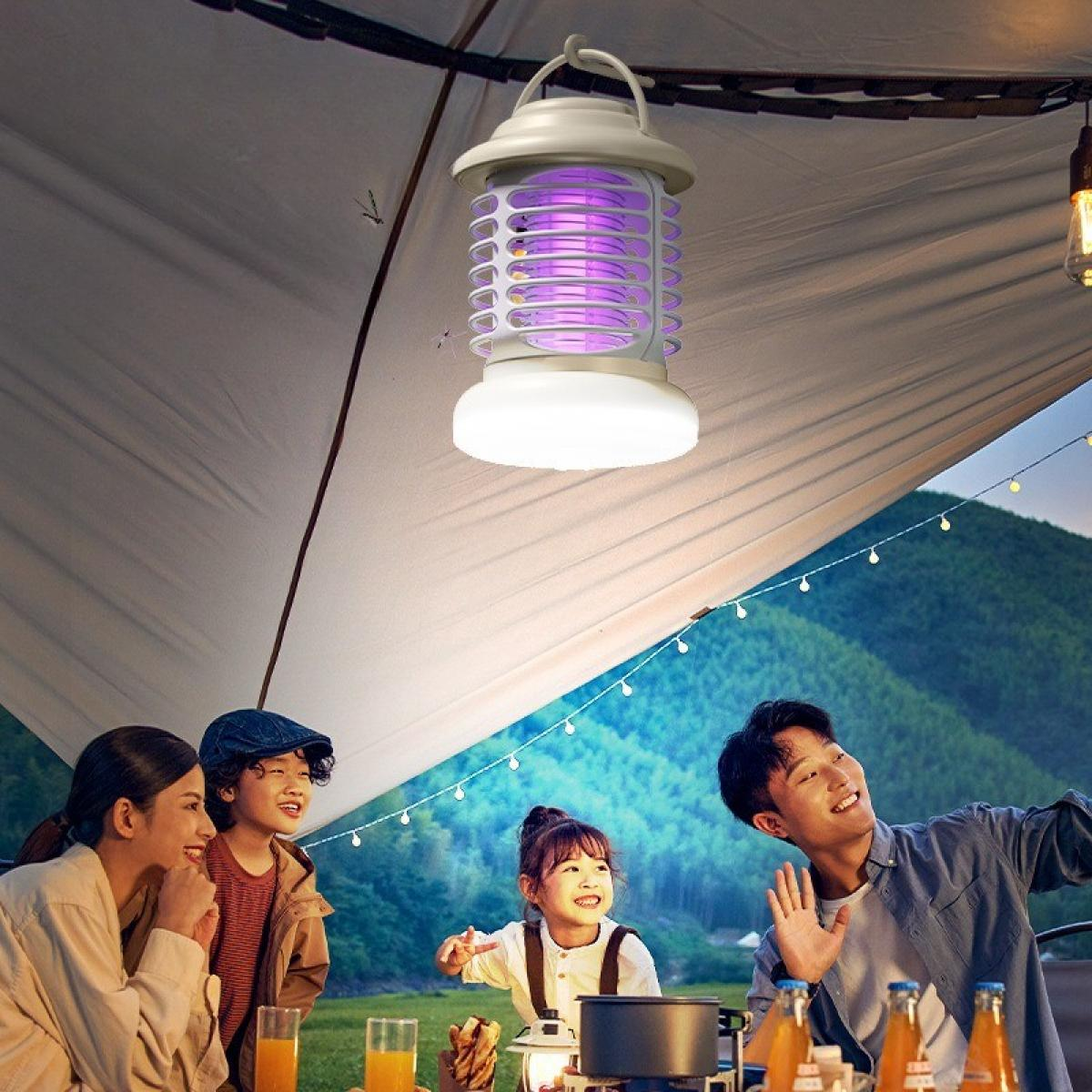 Familien-Camping. Ein hängender Insektenvernichter beleuchtet die Szene. Menschen lächeln, genießen die Natur, Orangensaft auf dem Tisch, Berg im Hintergrund.