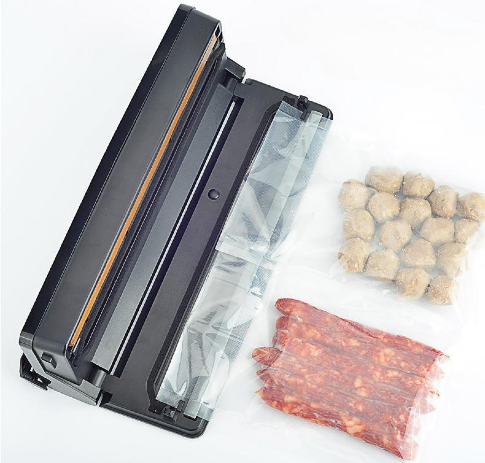 Ein Vakuumierer mit Lebensmitteln, darunter Fleischbällchen und Wurst, in durchsichtigen Plastiktüten, auf weißem Hintergrund.
