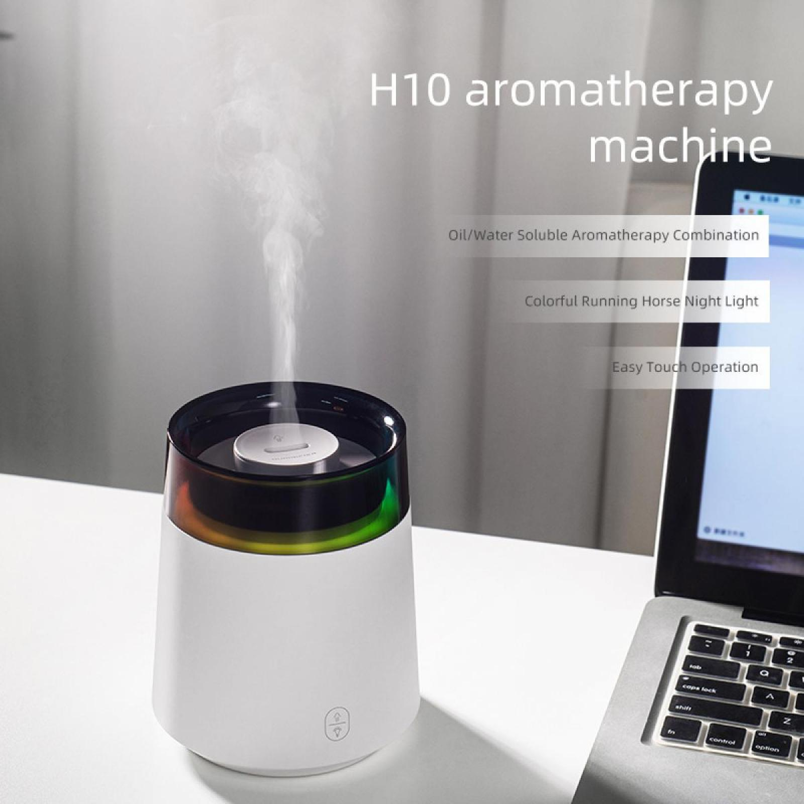 Weißer Aromatherapie-Gerät, das Dampf abgibt. Es hat eine farbwechselnde Oberseite und steht in der Nähe eines Laptops.