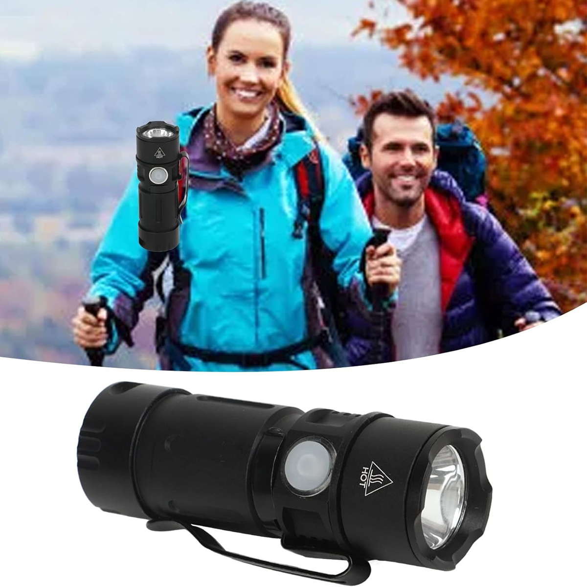 Eine schwarze Taschenlampe mit weißem Knopf ist im Fokus. Im Hintergrund lächeln zwei Wanderer, und Herbstlaub ist zu sehen.