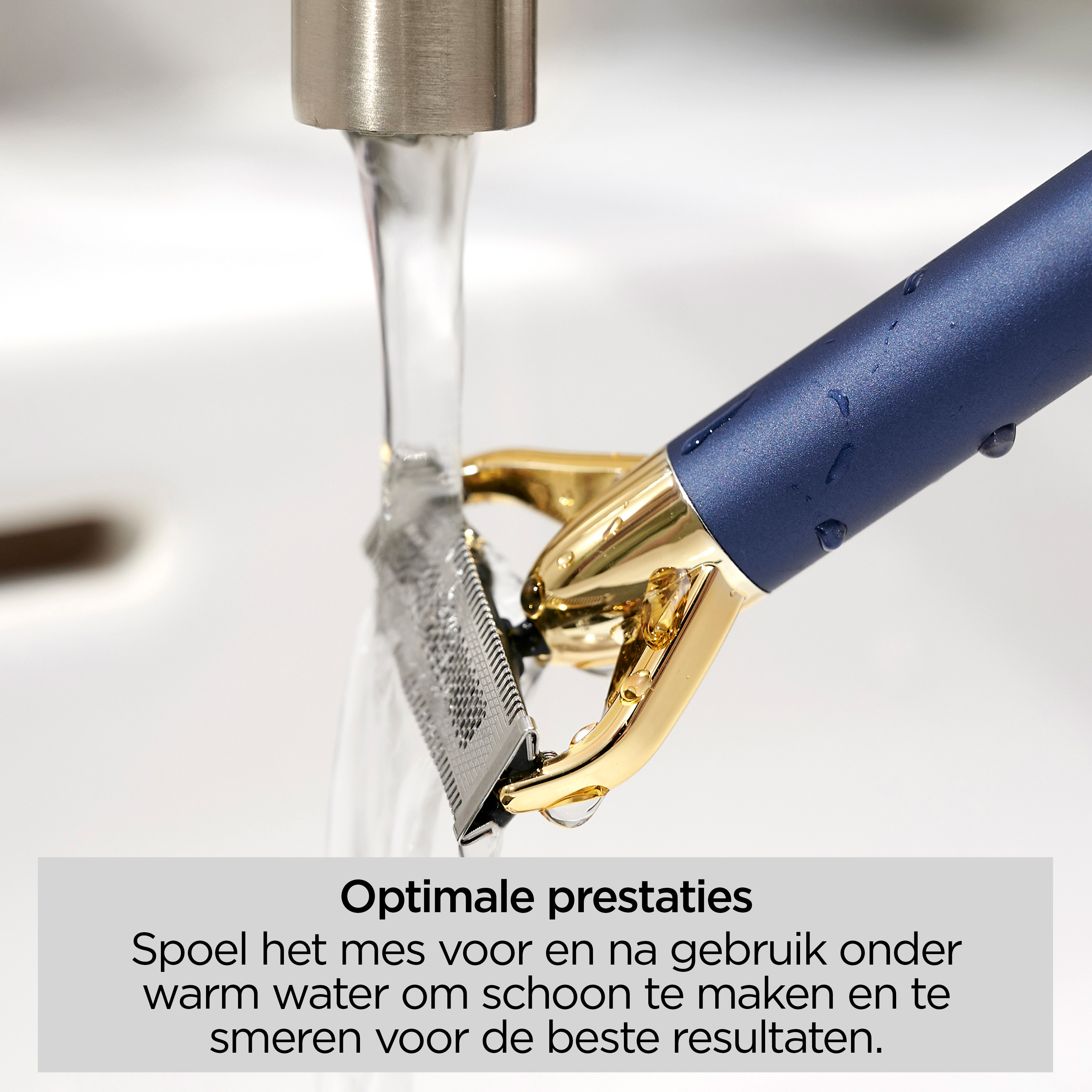 Een blauw-gouden trimmer wordt onder water gespoeld. Het mes is zilverkleurig. Waterdruppels zijn zichtbaar.