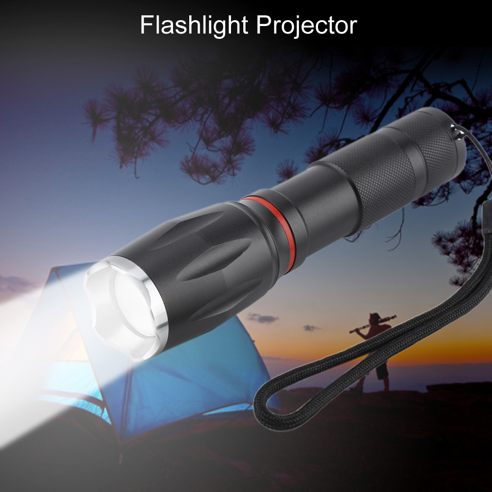 Eine schwarze Taschenlampe wirft einen Lichtstrahl auf ein blaues Zelt. Im Hintergrund steht eine Person mit einem Stock in der Nähe von Bäumen, bei Einbruch der Dunkelheit.