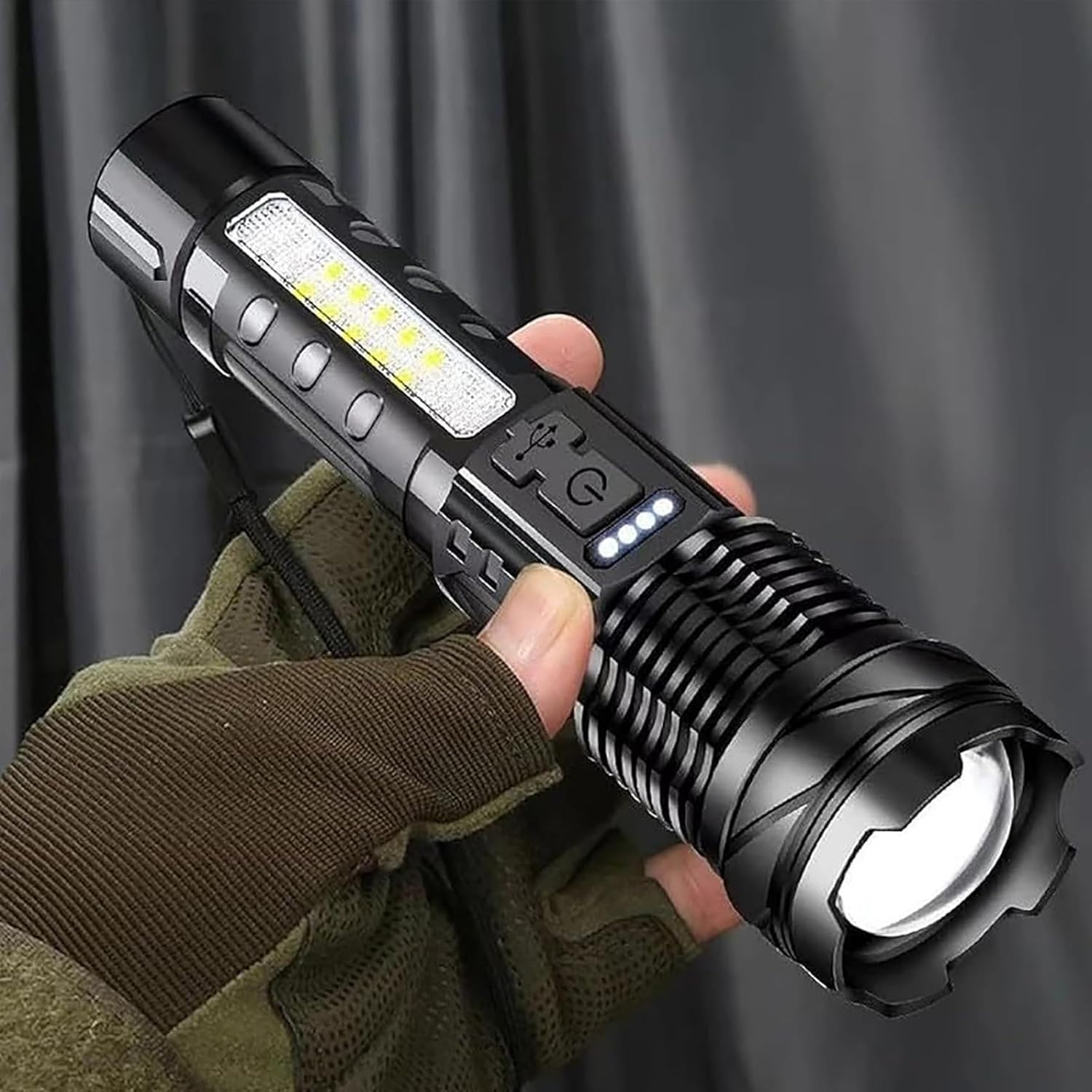 Eine schwarze Taschenlampe wird in einer behandschuhten Hand gehalten. Die Taschenlampe hat LED-Leuchten, einen Ein/Aus-Knopf und einen Ladeanschluss.
