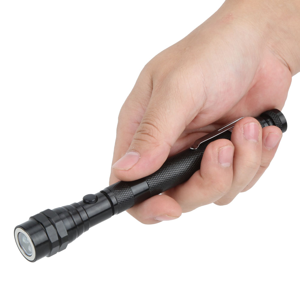 Eine Hand hält eine schwarze stiftförmige Taschenlampe. Das Licht ist an. Der Hintergrund ist weiß.