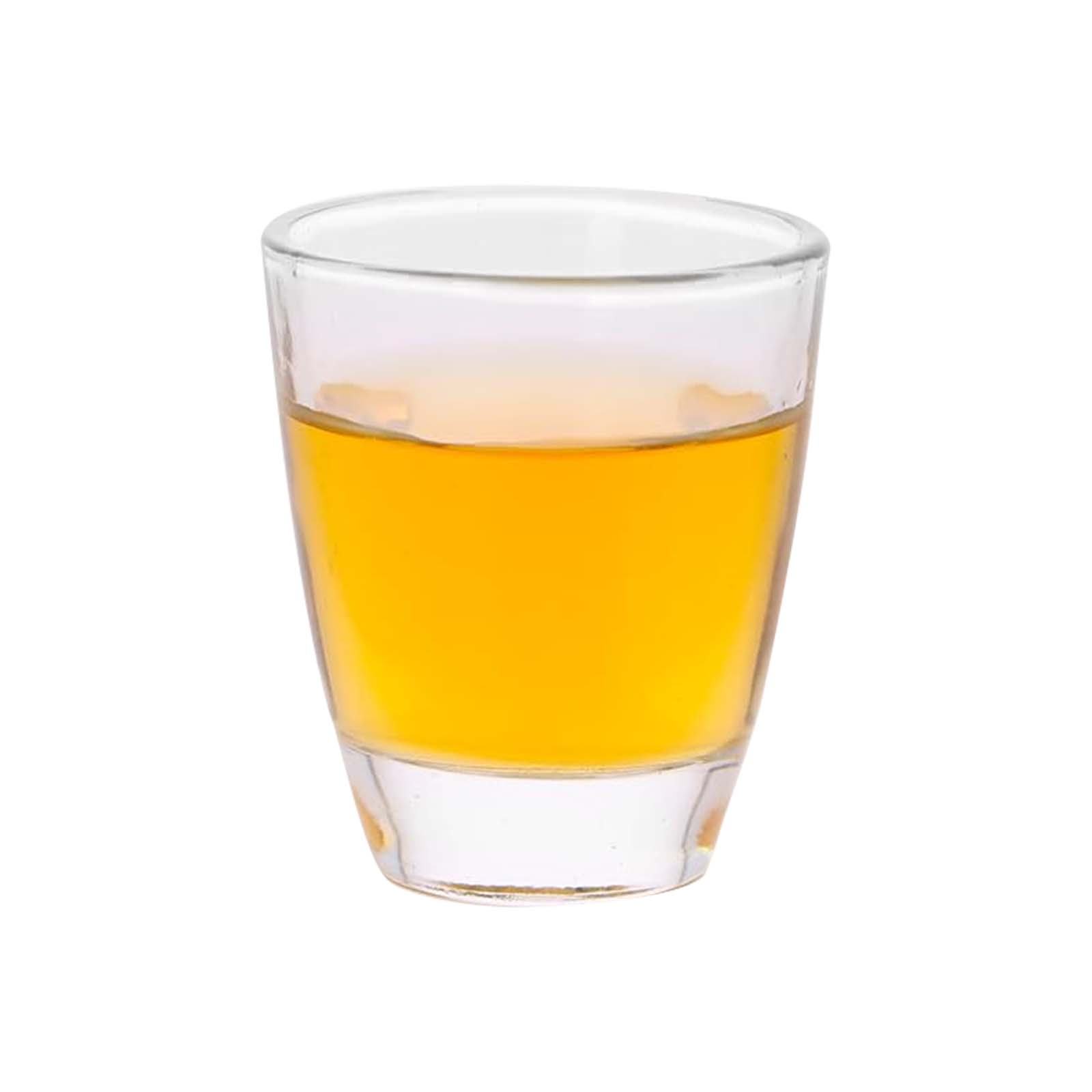Un bicchierino trasparente riempito di liquido giallo, probabilmente una bevanda, su sfondo bianco.