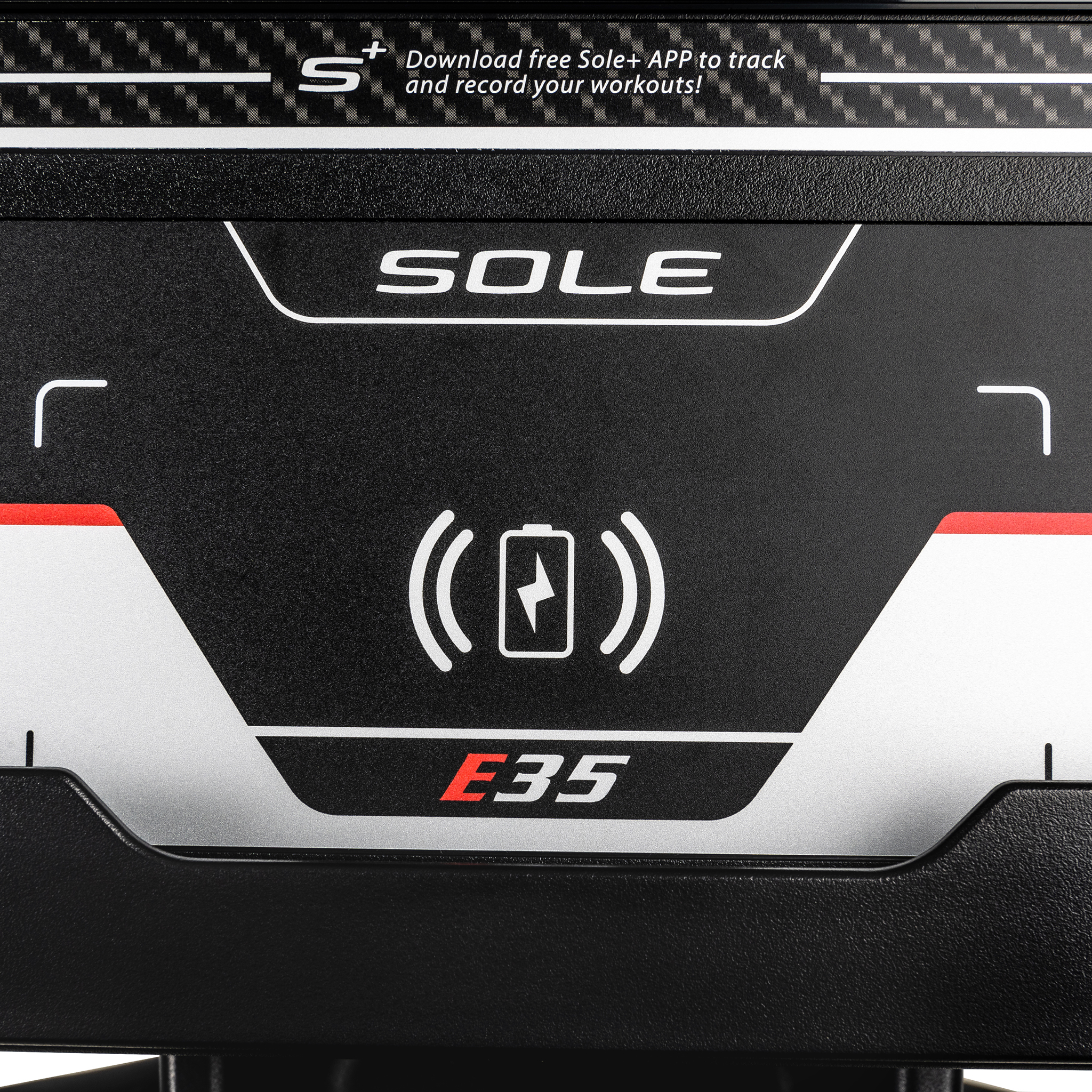 Schwarzes Fitness-Geräte-Panel mit weißem Text 'SOLE', 'E35', einem Akku-Ladesymbol und einem weißen Pluszeichen.