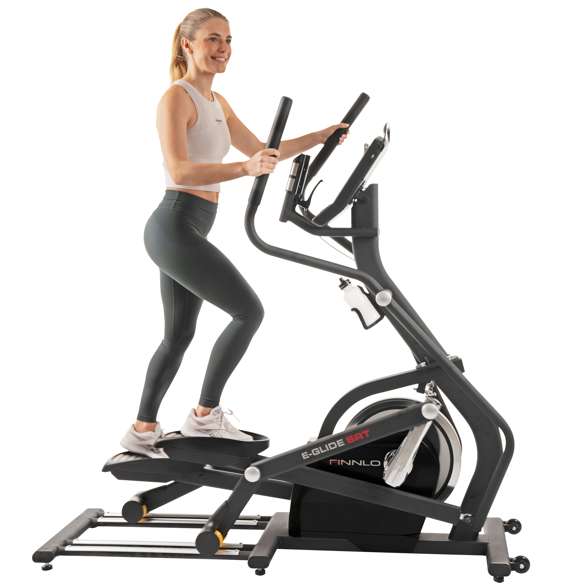 Eine Frau trainiert auf einem Crosstrainer. Sie trägt graue Leggings und ein weißes Oberteil. Die Maschine ist schwarz.