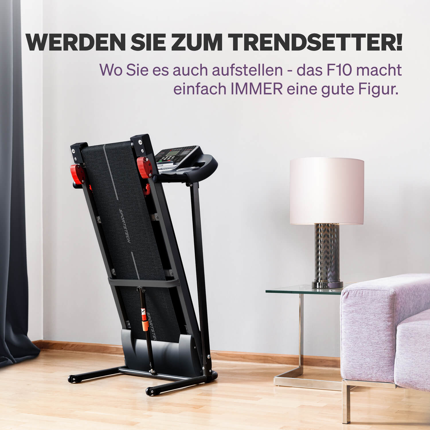 Ein schwarzes Laufband steht in einem Raum. Rechts sind eine Lampe und ein Sofa. Text an der Wand: 'Werden Sie zum Trendsetter!'